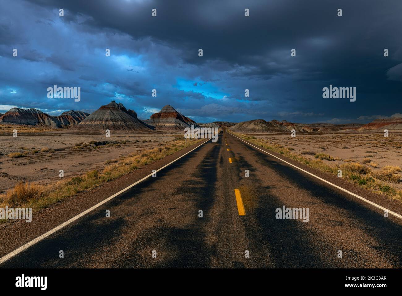 La remota strada nel cuore del Parco Nazionale della Foresta pietrificata mostra lo splendido scenario montano del deserto dipinto durante una tempesta Foto Stock