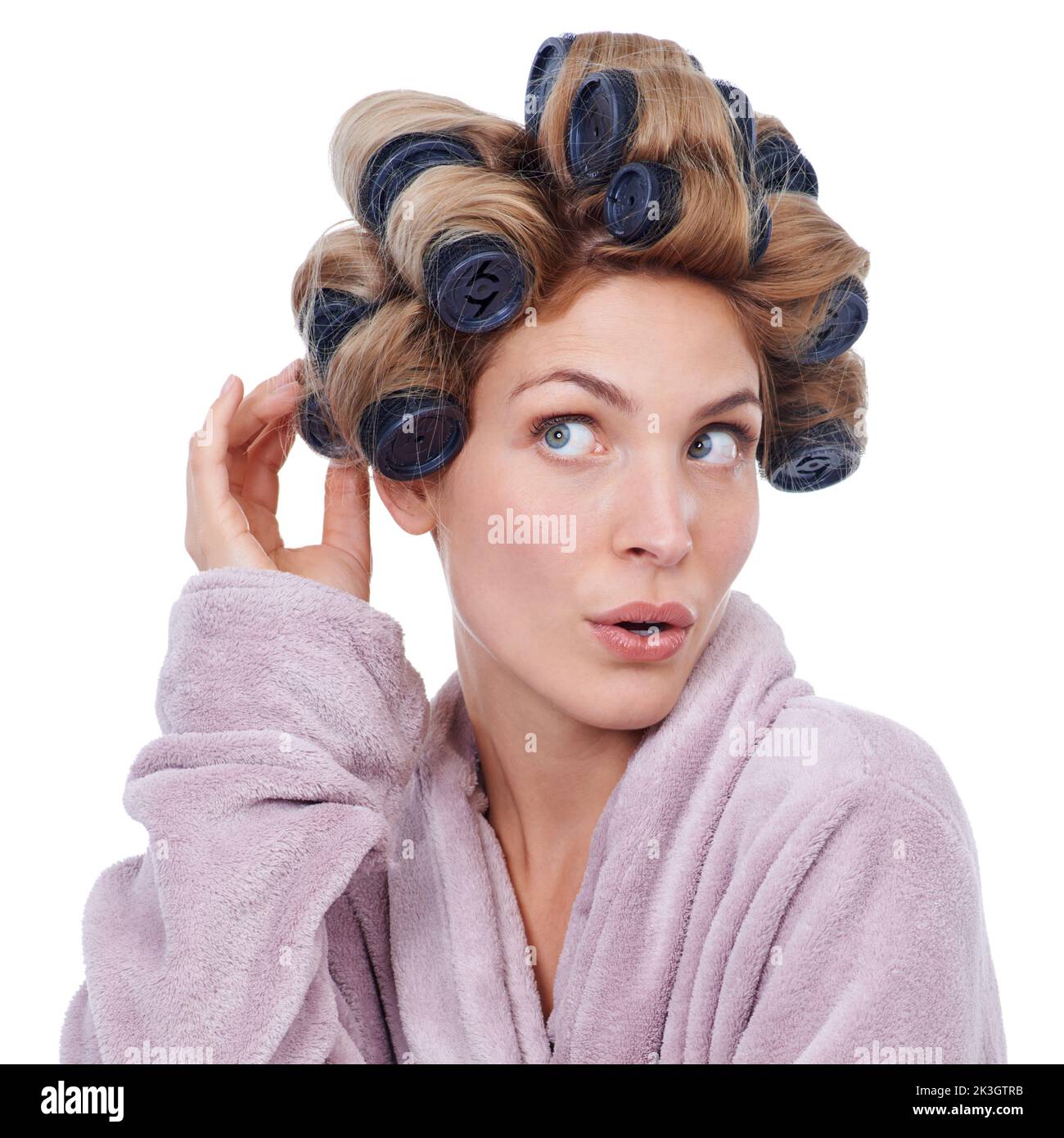 Quanto sarà curly. Studio shot di una giovane donna in rulli per capelli e un vestiolo. Foto Stock