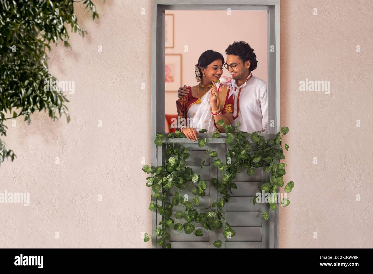 Felice coppia bengalese in piedi insieme dalla finestra Foto Stock