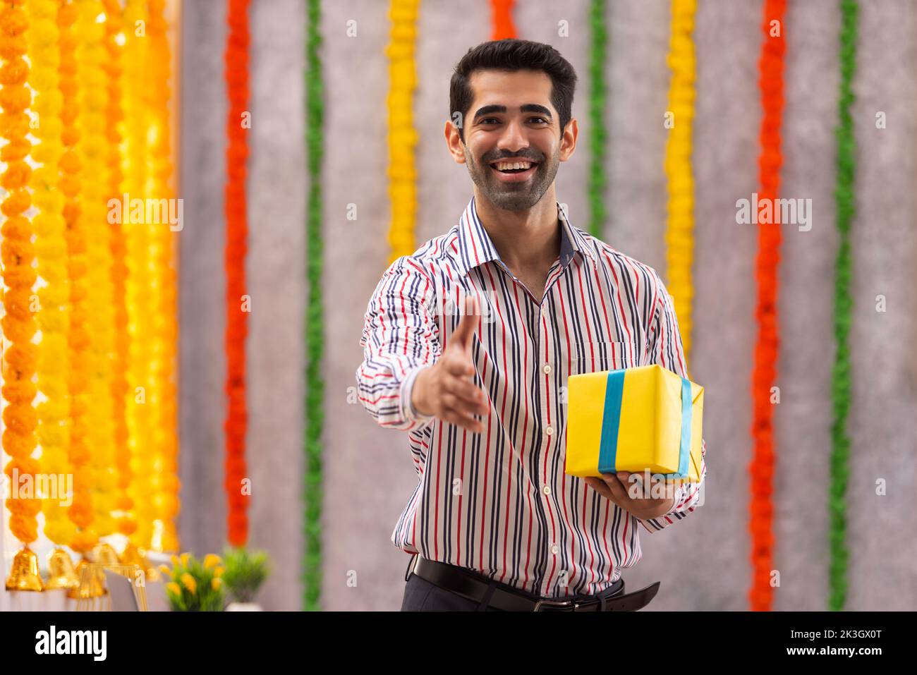 Ritratto di un giovane sorridente che sta per scuotere le mani in carica durante la celebrazione di Diwali Foto Stock