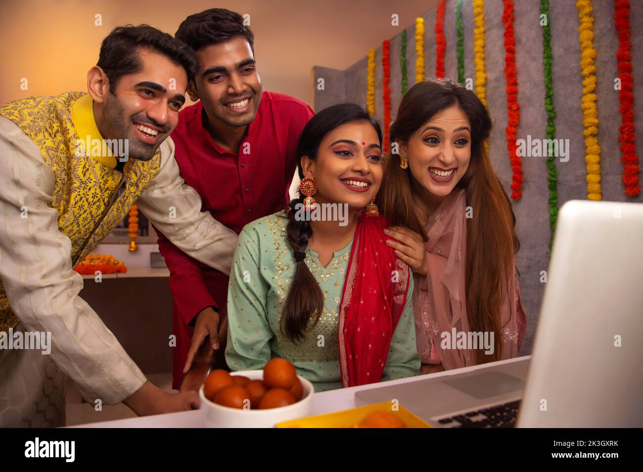 I colleghi che hanno videochiamata insieme sul portatile in ufficio durante la celebrazione di Diwali Foto Stock