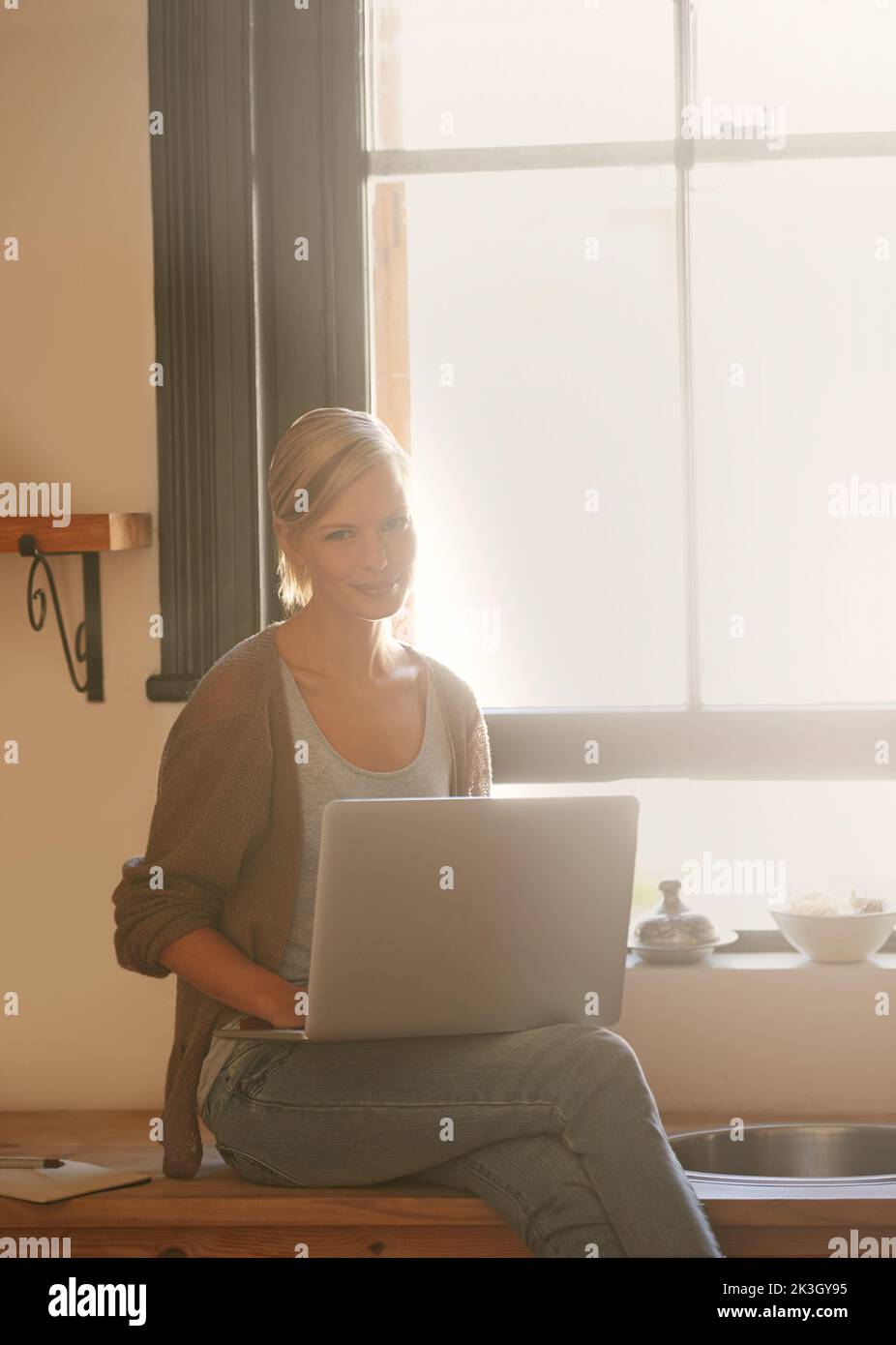 Il luogo più caldo in cui lavorare a casa. Una giovane donna attraente che usa il suo notebook mentre si rilassa a casa. Foto Stock