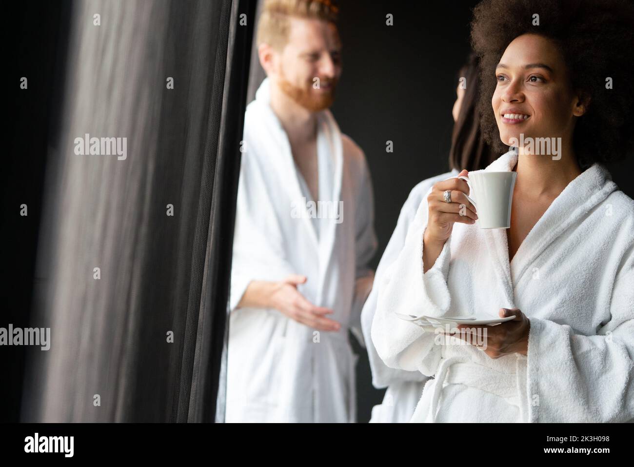 Bellissima donna nera che si rilassa nella lussuosa spa dell'hotel indossando accappatoio e bere caffè Foto Stock