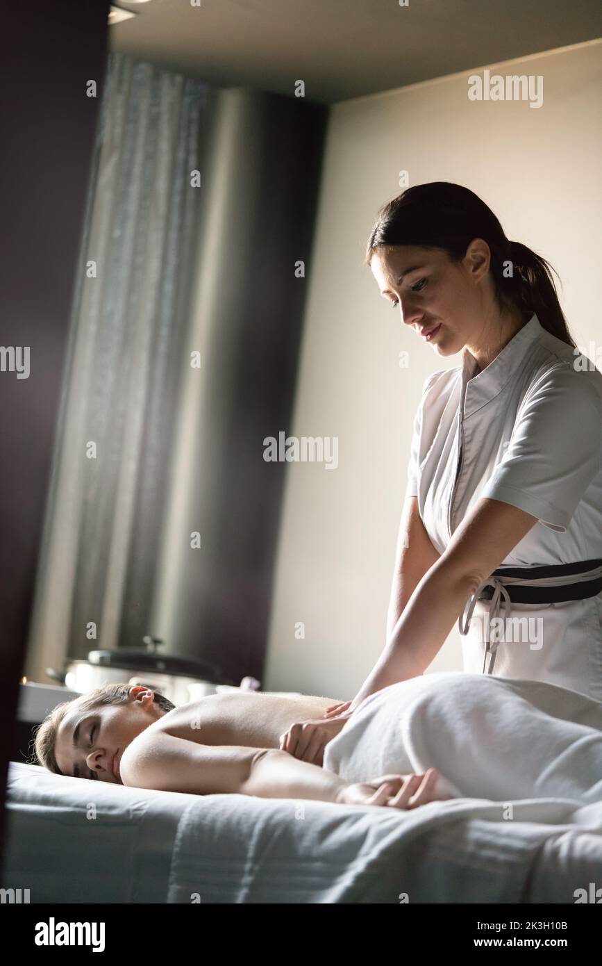 Donna sana con massaggi terapeutici presso il salone termale Foto Stock