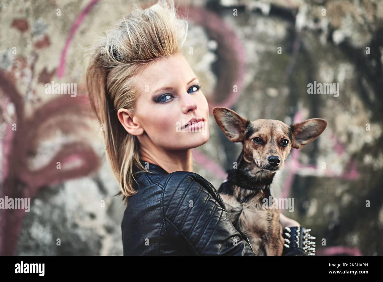 Stavano diventando urbano, dawg. Ritratto corto di una giovane donna edgy che tiene il suo piccolo cane in un ambiente urbano. Foto Stock