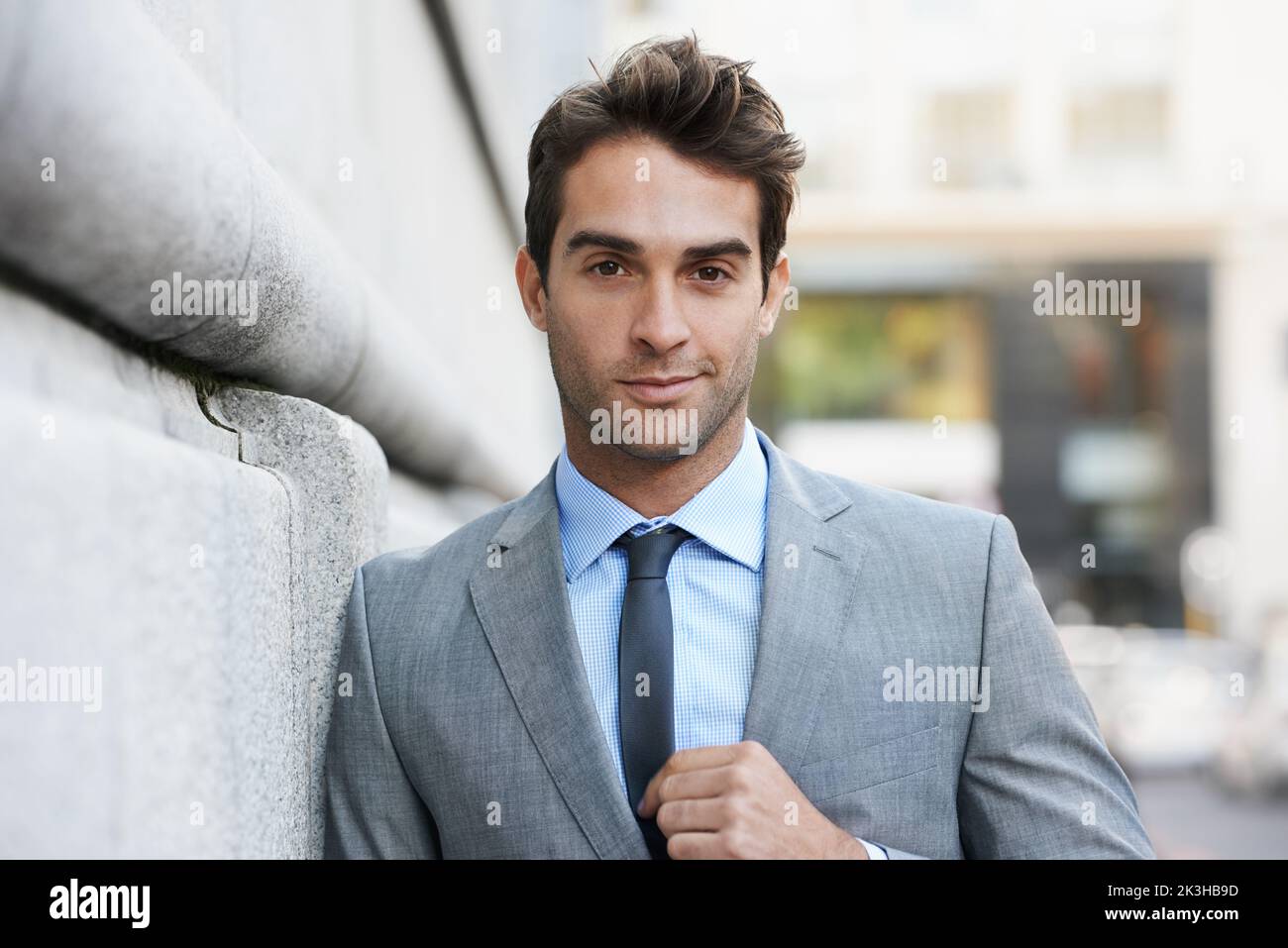 Lavorare in città. Un bel giovane uomo d'affari che guarda la fotocamera. Foto Stock