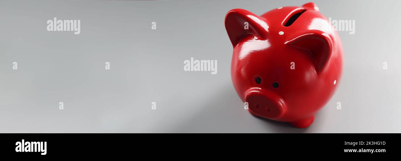 Contenitore piggybank rosso brillante sulla superficie grigia, cosa vuota per mettere soldi Foto Stock