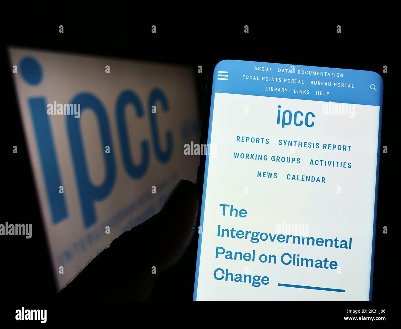 Persona che tiene il cellulare con il sito web del Gruppo intergovernativo sul cambiamento climatico (IPCC) sullo schermo con il logo. Messa a fuoco al centro del display del telefono. Foto Stock