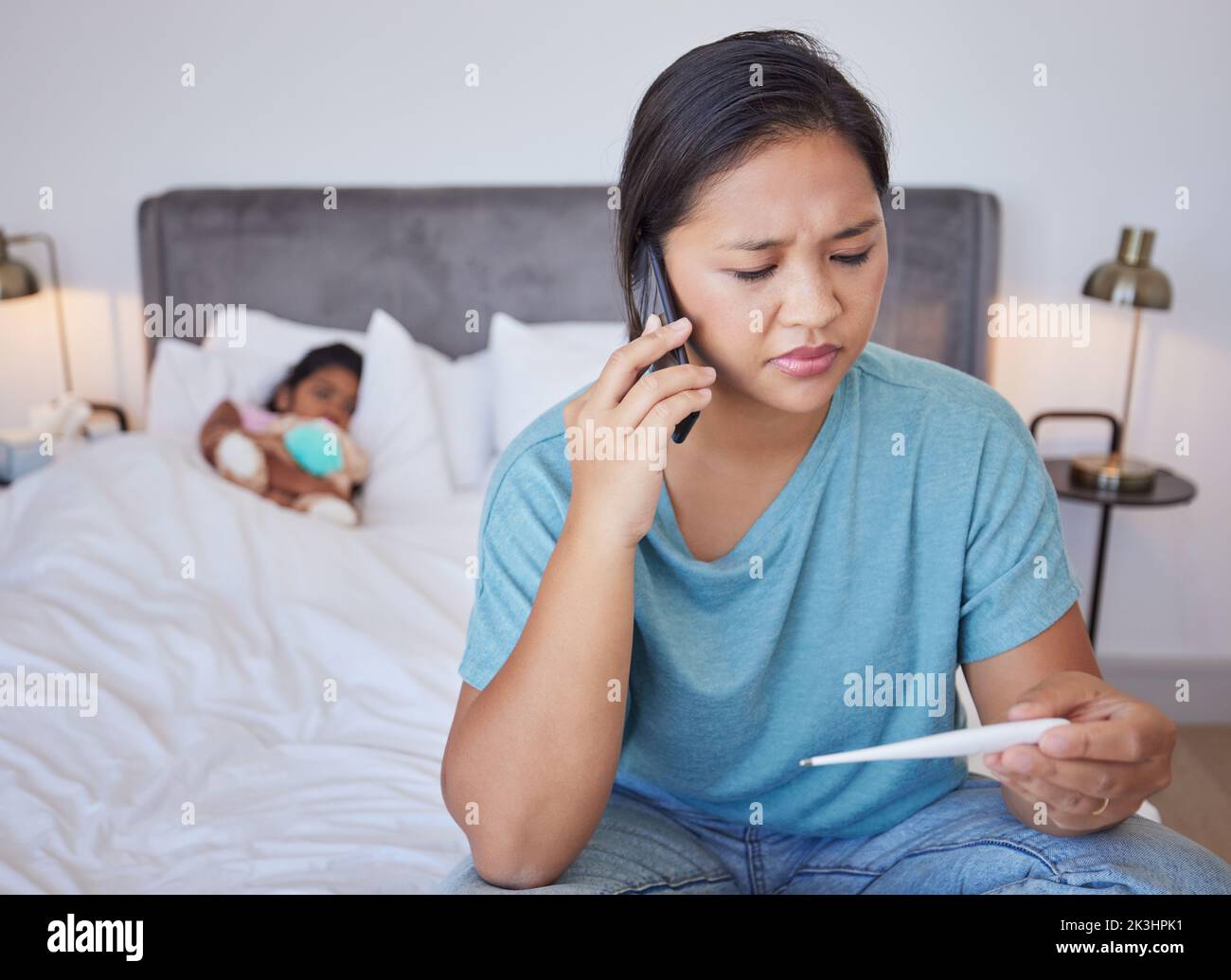 Telefono cellulare madre chiamata medico per il bambino malato, virus e febbre in camera da letto a casa. Preoccupato Taiwan genitore che consulta l'assistenza sanitaria mobile per la temperatura calda Foto Stock