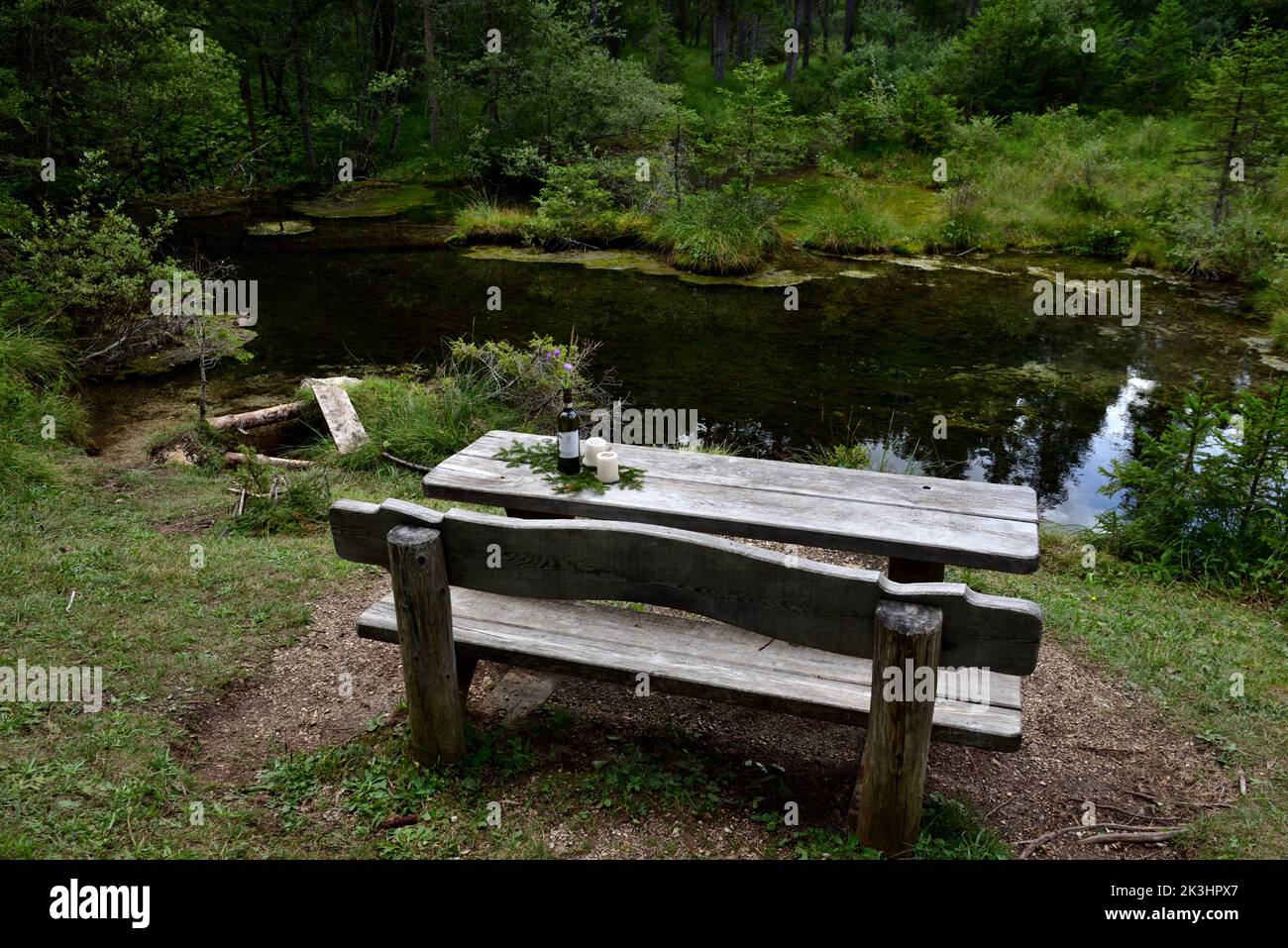 Un tavolo rustico in legno in un luogo romantico pronto ad accogliere chiunque voglia concedersi un momento di relax Foto Stock