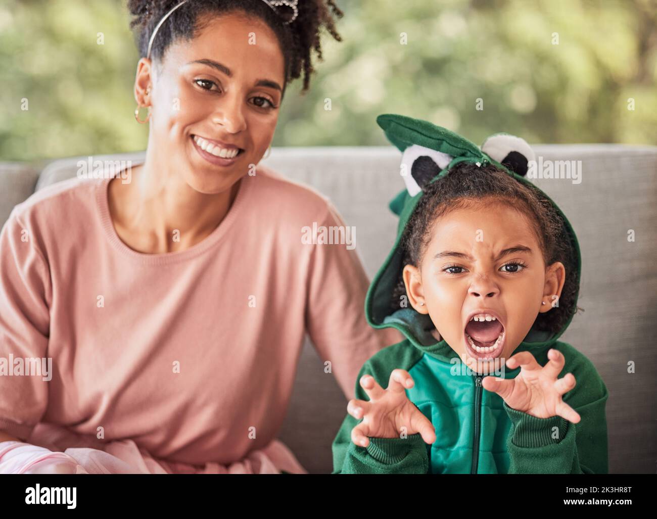 Ritratto di madre e bambino che gioca, divertendosi con il costume e l'incollaggio su un divano a casa. Fantasia, gioco e genitore creativo godendo di un divertente Foto Stock