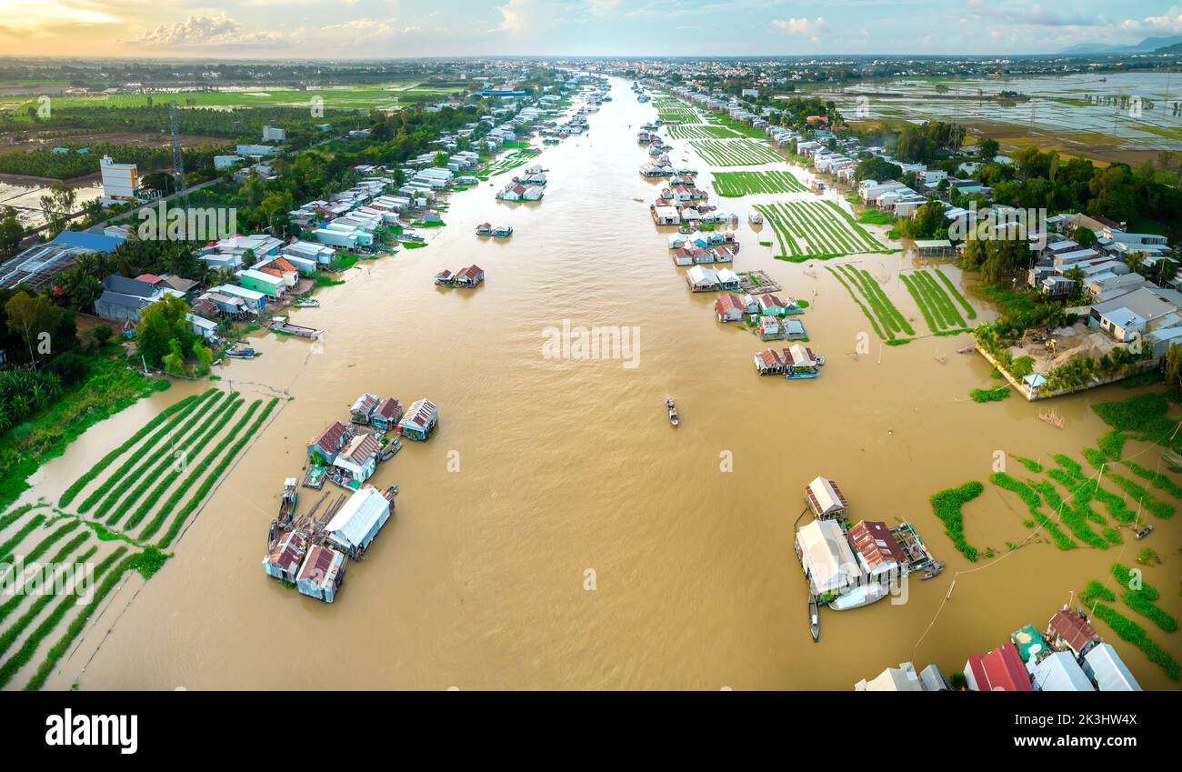 Villaggio galleggiante lungo il fiume Hau sopra la zona di confine del Vietnam, vista aerea. Il bacino del fiume contiene molti frutti di mare e alluvione per l'agricoltura Foto Stock