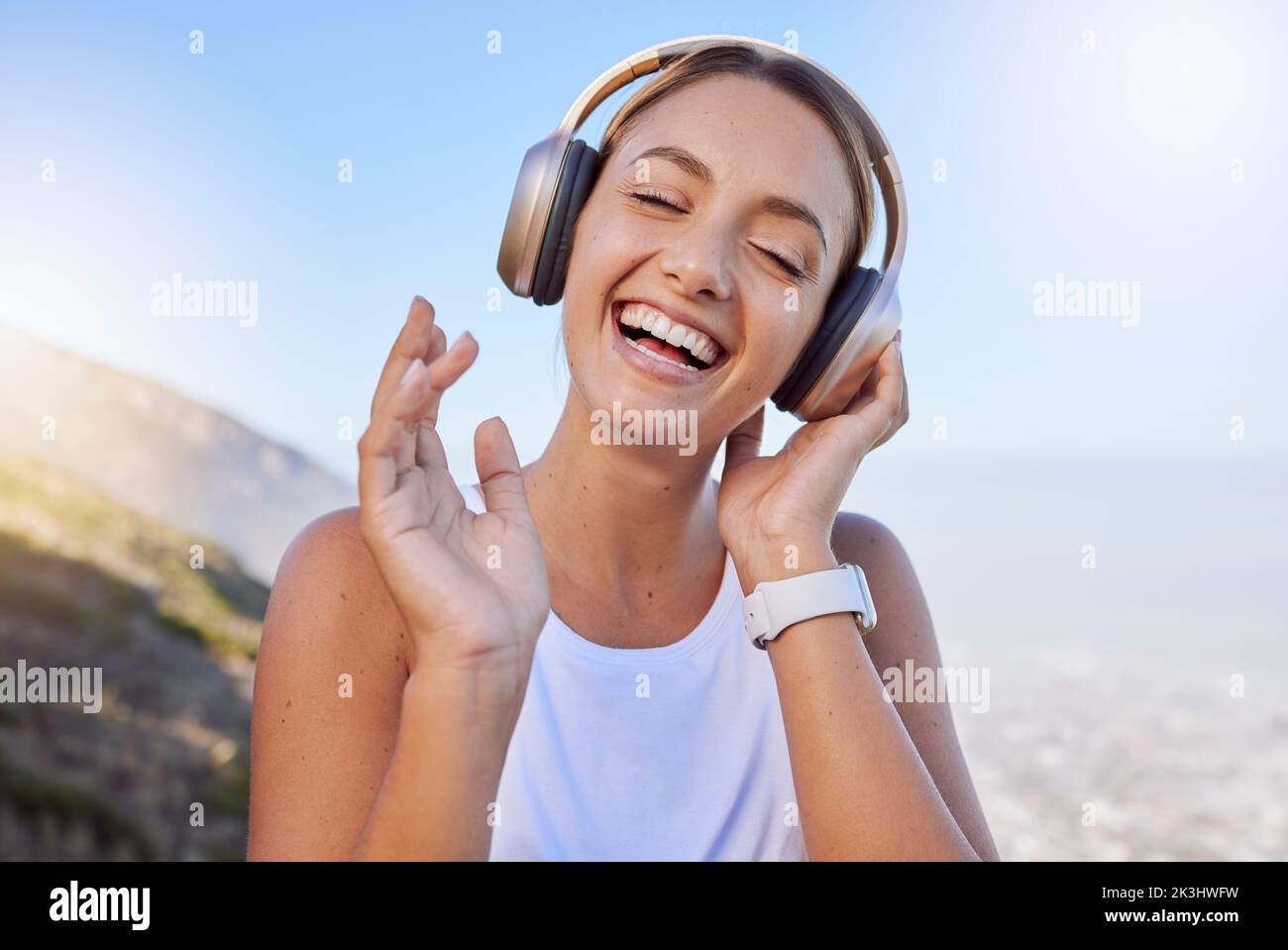 Sorridete, ridete e camminate con le cuffie per allenarvi, allenarvi o allenarvi nelle montagne della campagna. Felice, viso e comico atleta ascoltare Foto Stock