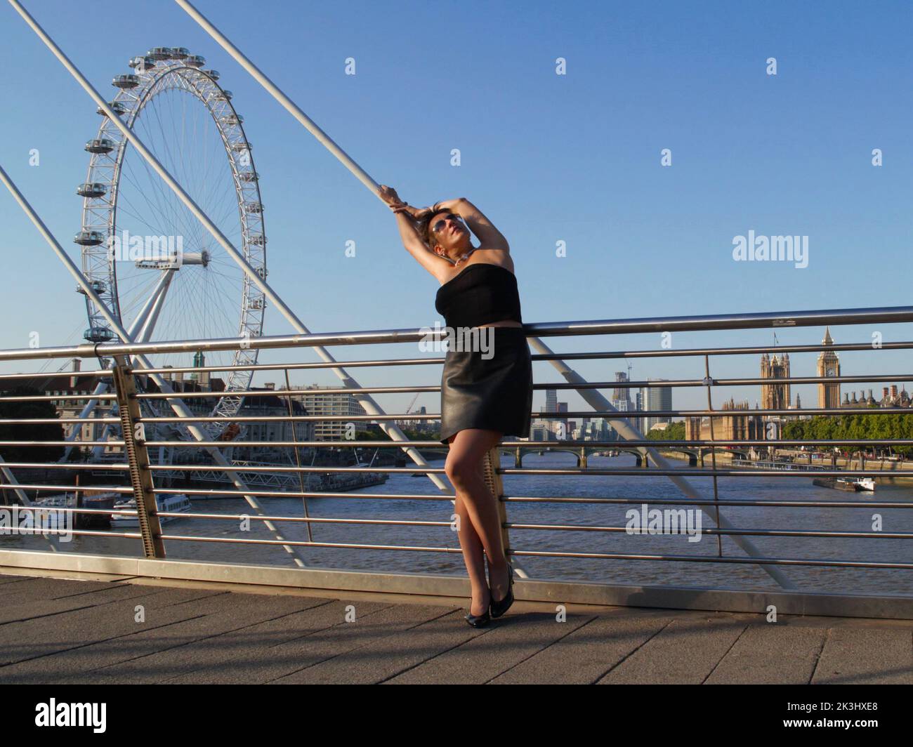 Ritratto completo di una donna in posa sul Golden Jubilee Bridge con London Eye sullo sfondo, Londra, Regno Unito. Modello: L'appello universale. Foto Stock