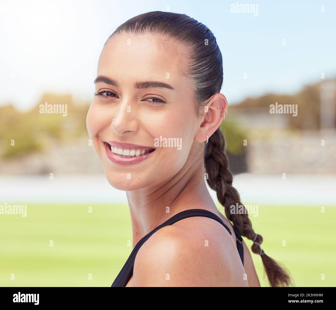 Fitness all'aperto, donna in ritratto per l'esercizio fisico o la motivazione di allenamento, fiducia e stile di vita benessere sul campo sportivo. Atleta statunitense professionista Foto Stock