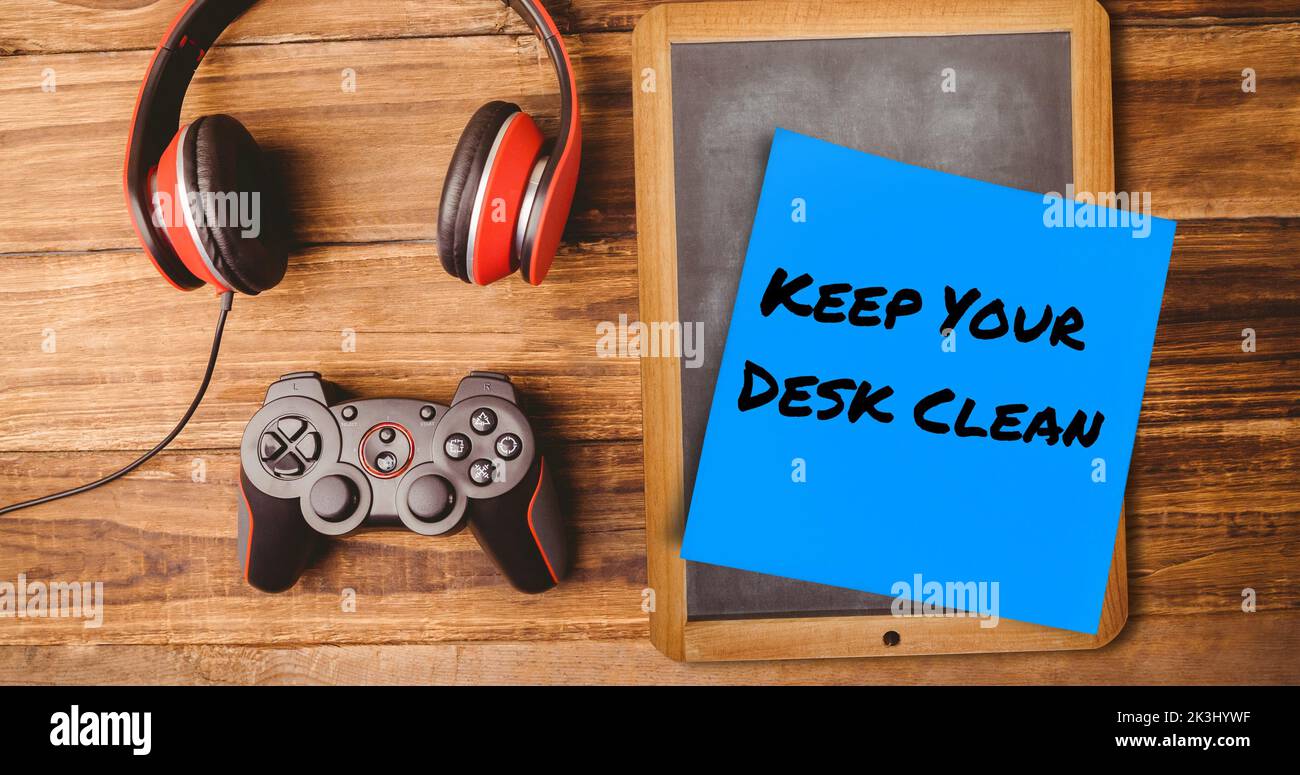 Composito di sticky note con mantenere la vostra scrivania pulito testo, ardesia, cuffie e controller di gioco Foto Stock