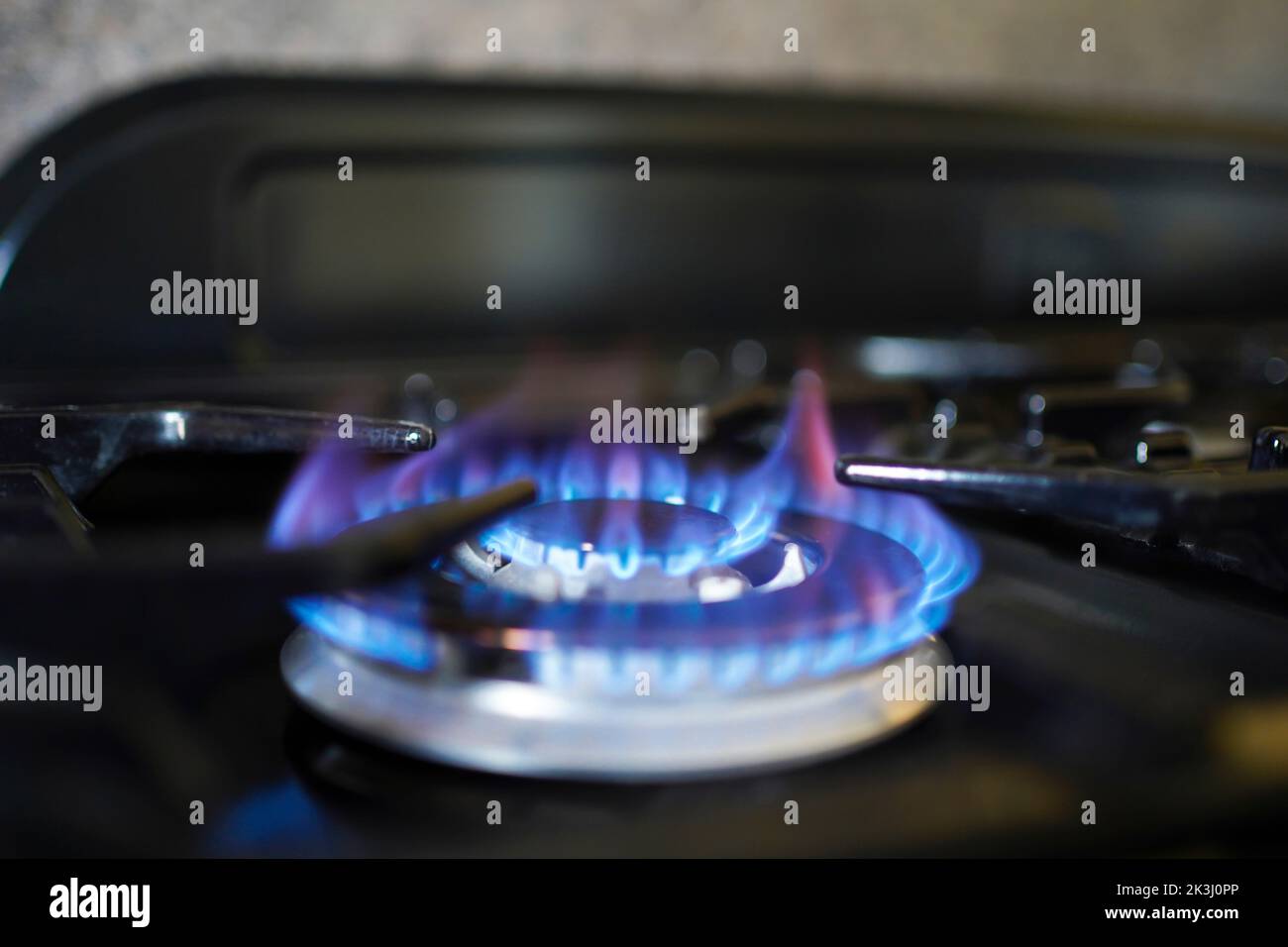Cucinare con il gas diventa difficile come il costo di vivere sta aumentando a livello catastrofico. Crisi energetica nazionale. Fiamma blu su un anello di gas del fornello. Foto Stock