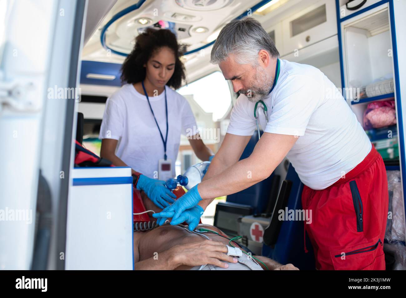 I medici dell'ambulanza che eseguono la rianimazione cardiopolmonare su un paziente critico Foto Stock