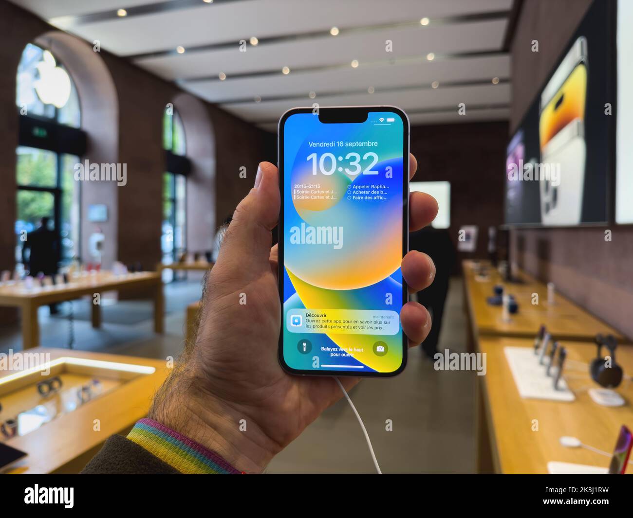 Parigi, Francia - 16 settembre 2022: POV mano maschio tenere nuovo color viola Apple computer iPhone 14 durante il giorno di lancio con la nuova fotocamera doppia potente auto rilevamento urti e satellite SOS Foto Stock