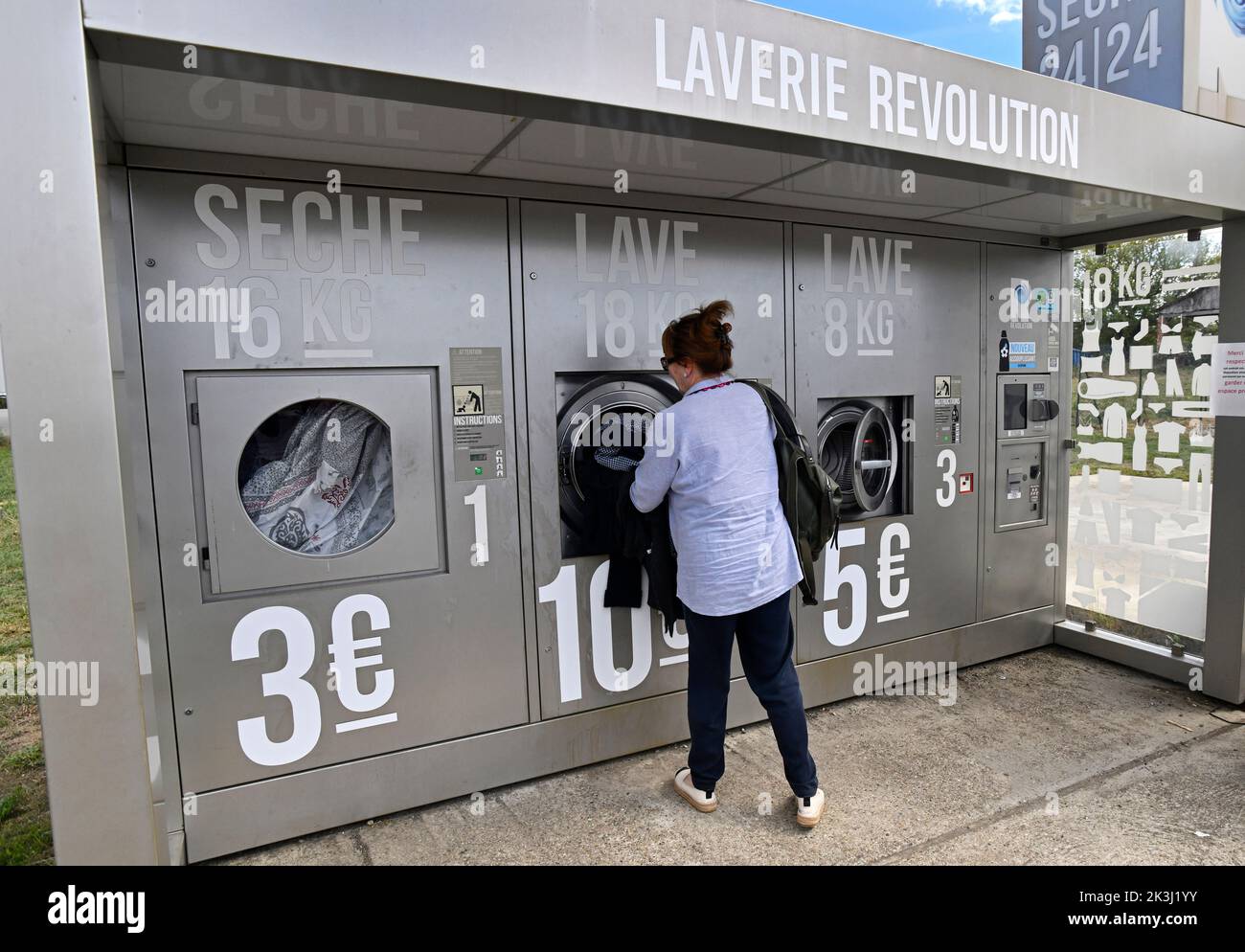 Donna che usa una lavanderia esterna chiamata Laverie Revolution in Francia Foto Stock