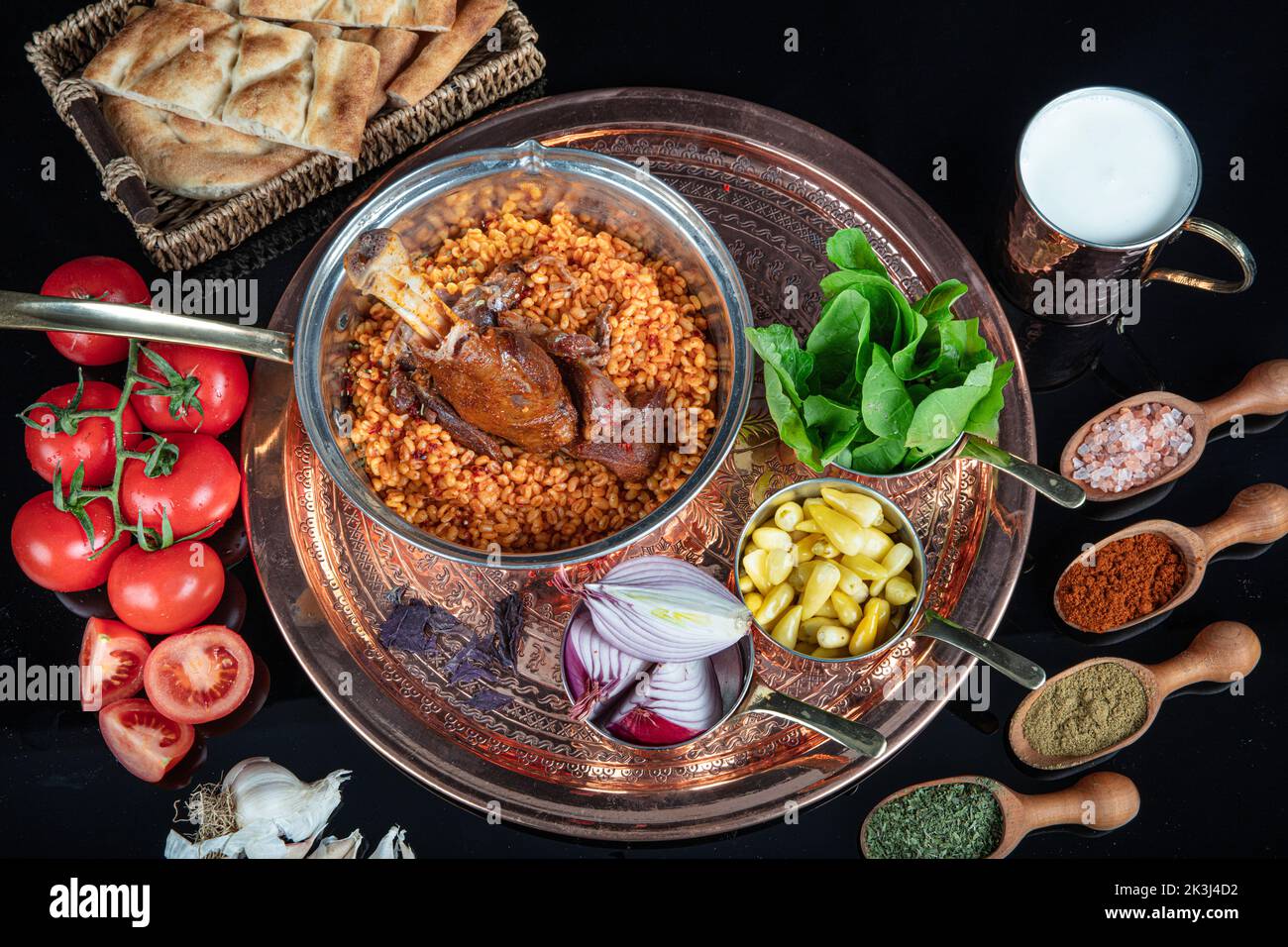 Tradizionale turco cibo gambo di agnello e riso. Gambo di agnello cotto lento. Gambo di agnello servito su un vassoio di rame e in una ciotola di rame. Foto Stock