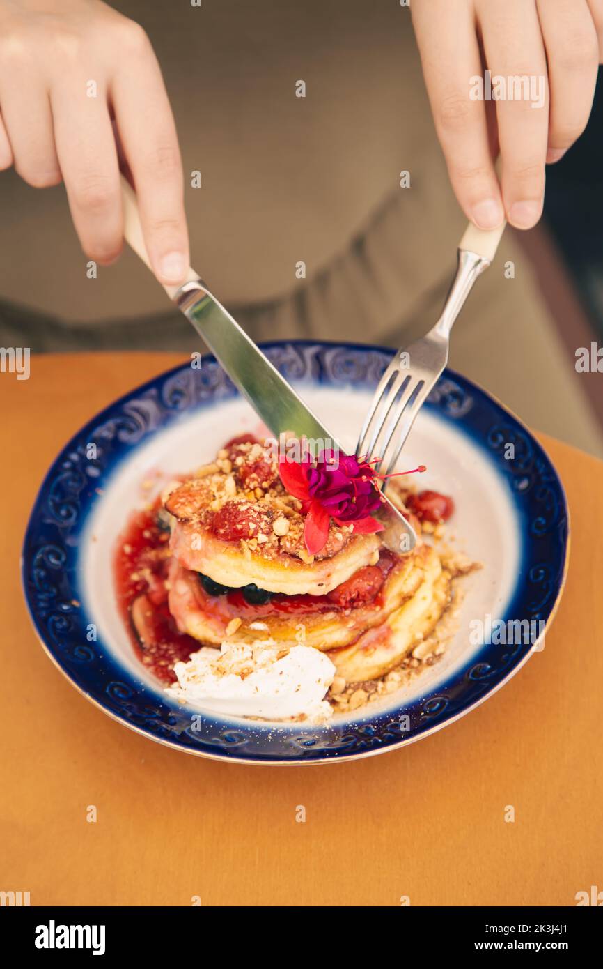 Appetitose frittelle decorate con frutti di bosco e fiori. Foto Stock