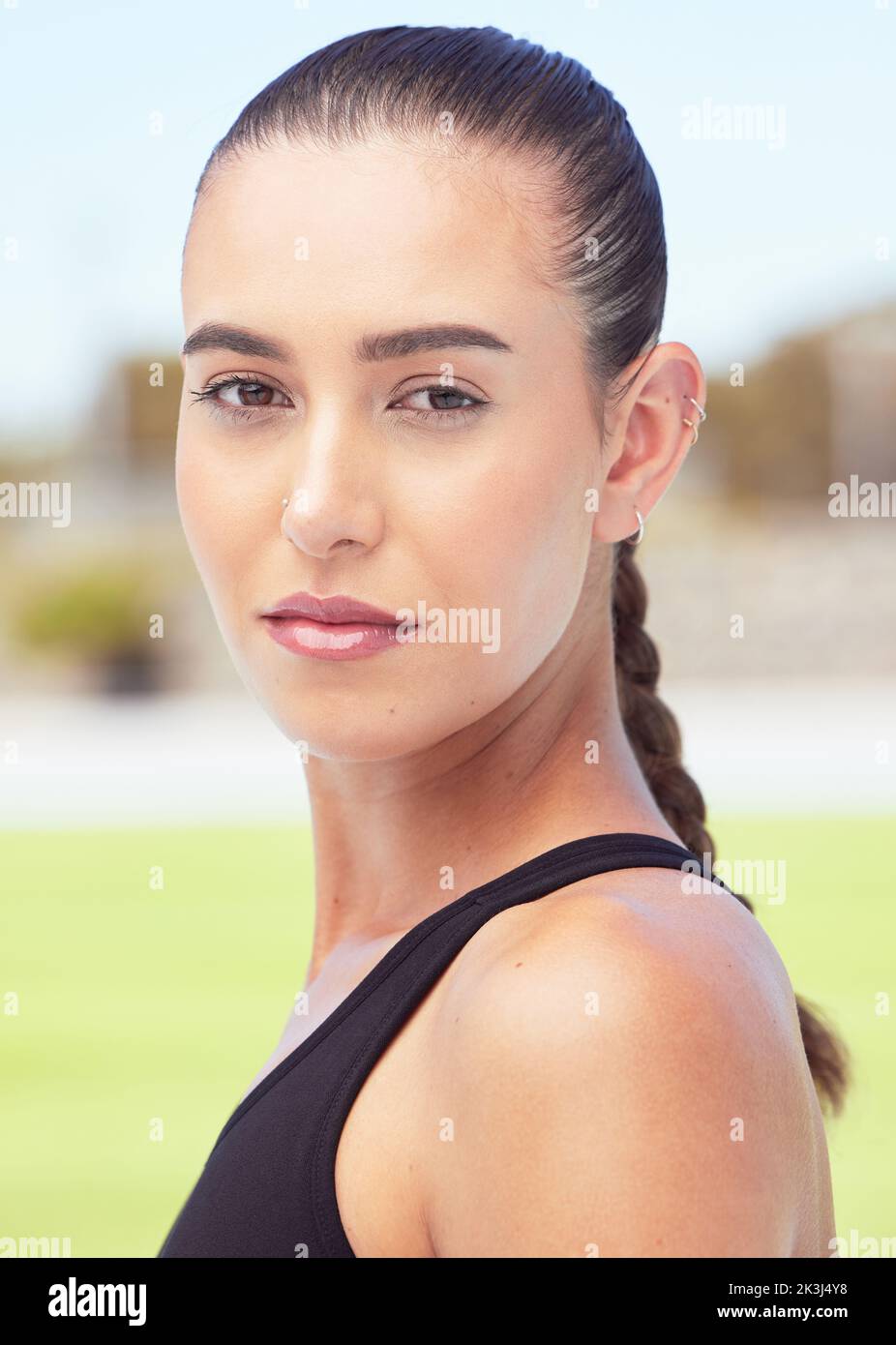 Ritratto di atleta, donna fitness e runner focus su pista sportiva per gara, gara di maratona e allenamento cardio. Serio, giovane e sano Foto Stock