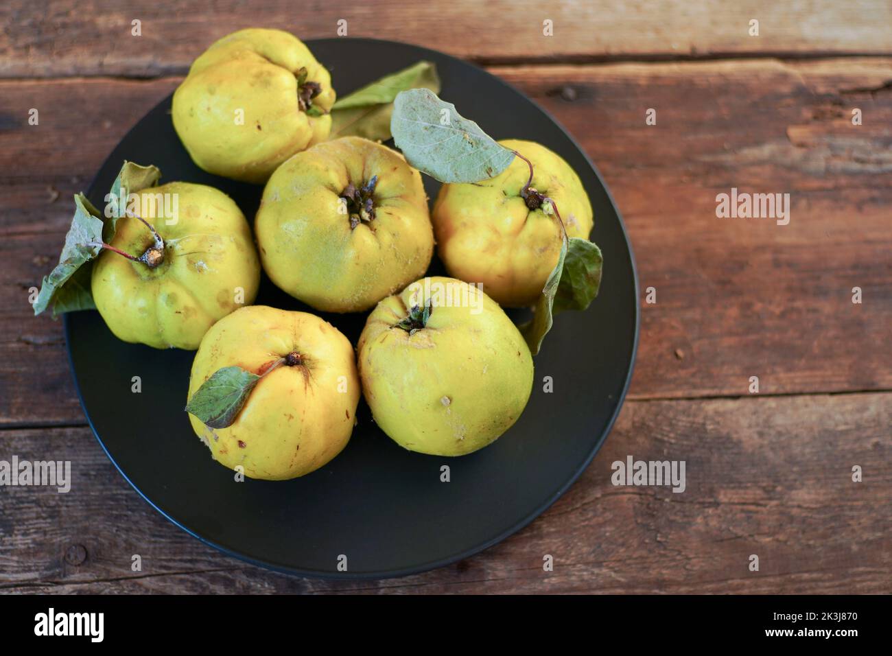 Frutta di mela cotogna. Vita morta su sfondo di legno. Frutti di mela cotogna maturi. Cibo vitaminico. Foto Stock