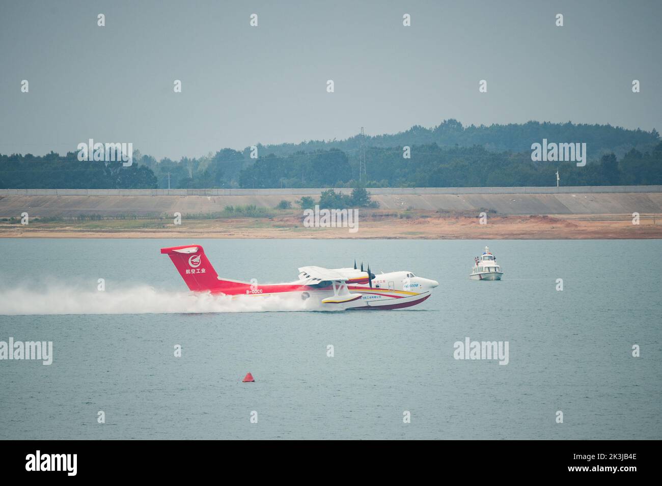 Jingmen, Provincia cinese di Hubei. 27th Set, 2022. Un aereo antincendio del AG600M raccoglie l'acqua durante un test di raccolta e caduta dell'acqua a Jingmen, provincia di Hubei, nella Cina centrale, il 27 settembre 2022. Nome in codice Kunlong, la grande famiglia di aerei anfibi del AG600 è considerata come attrezzatura aeronautica chiave per il sistema di emergenza-salvataggio della Cina. È stato sviluppato dalla Aviation Industry Corporation of China (AVIC), il principale costruttore di aerei del paese, per soddisfare le esigenze delle missioni antincendio e di salvataggio in mare, nonché di altre operazioni critiche di emergenza. Credit: WU Zhizun/Xinhua/Alamy Live News Foto Stock