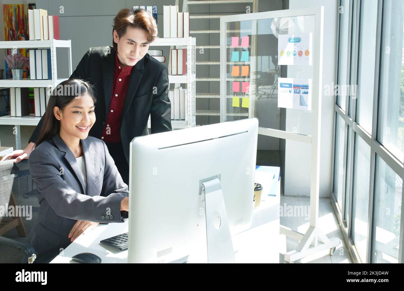Uomo e donna asiatica d'affari che guarda lo schermo del computer portatile per discutere e lavorare in ufficio Foto Stock