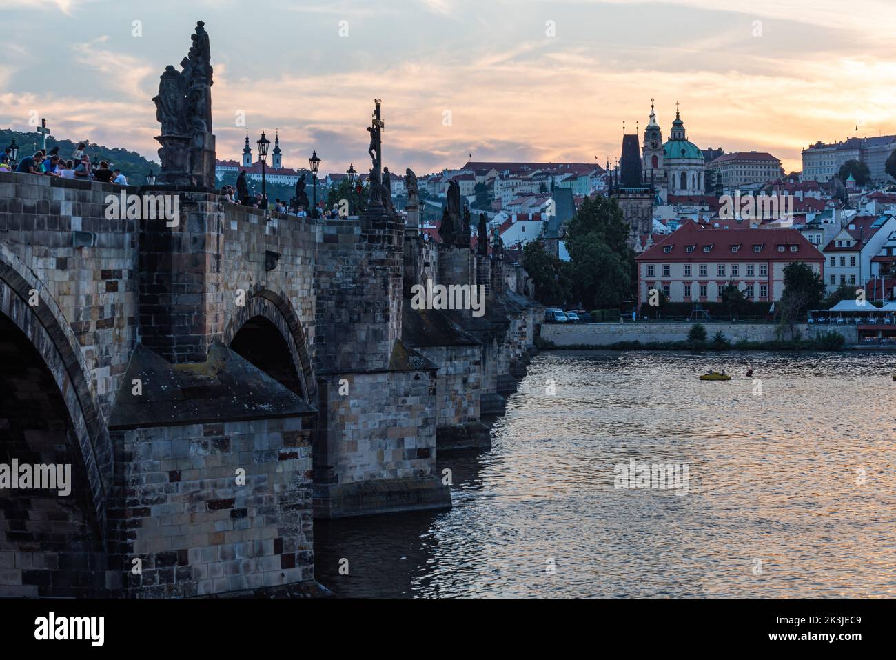 Praga - Repubblica Ceca - 08 01 2020 turisti in abiti estivi a piedi sul ponte Carlo durante una notte d'estate con un cielo colorato Foto Stock
