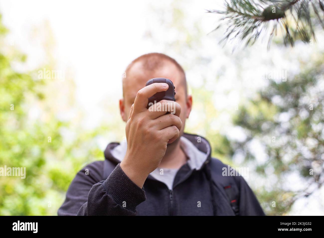 Un uomo con un navigatore nella foresta. Orientamento della posizione. Ricezione del segnale GPS, tecnologia Foto Stock