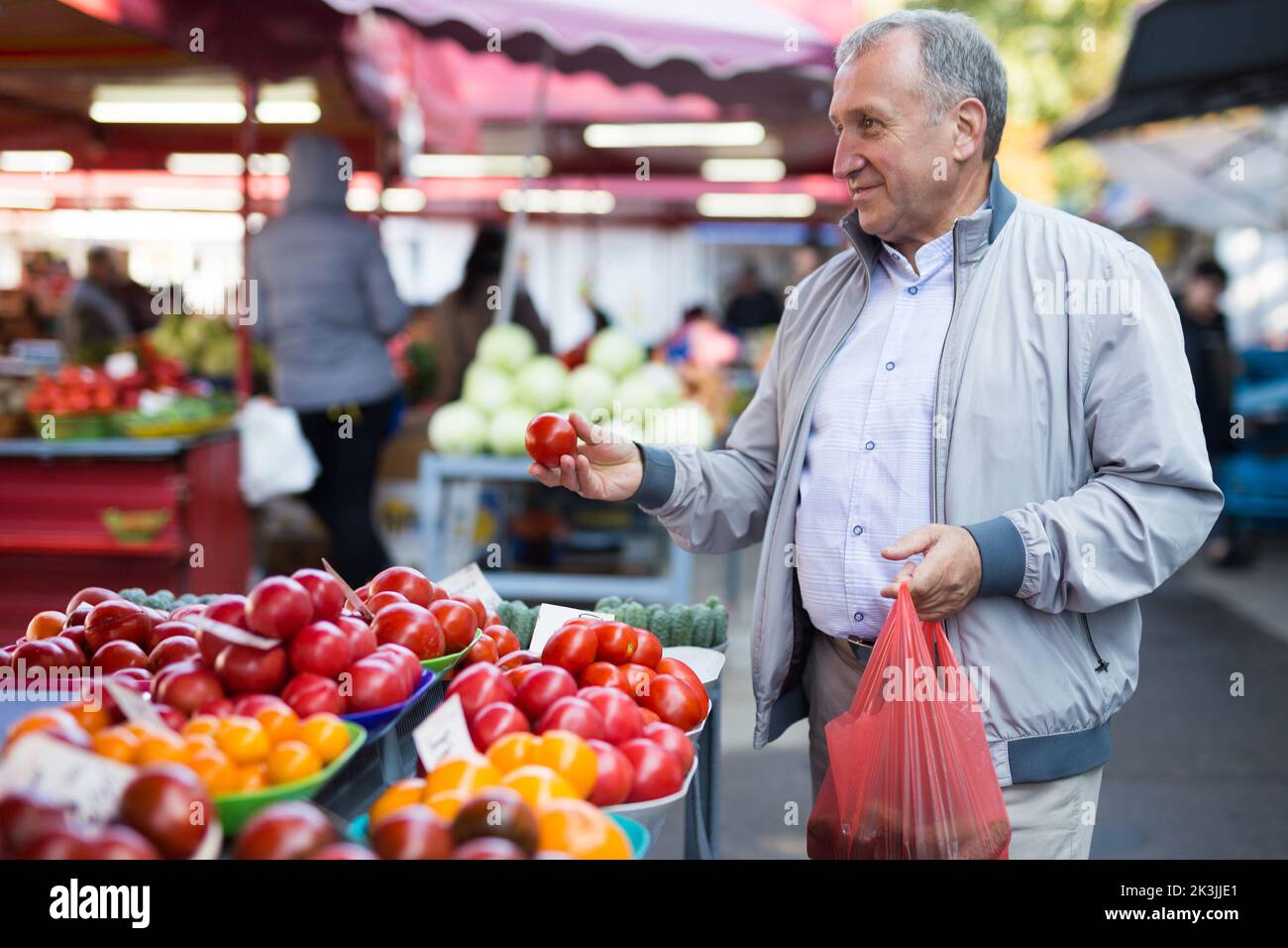 Uomo di mezza età che acquista pomodori Foto Stock