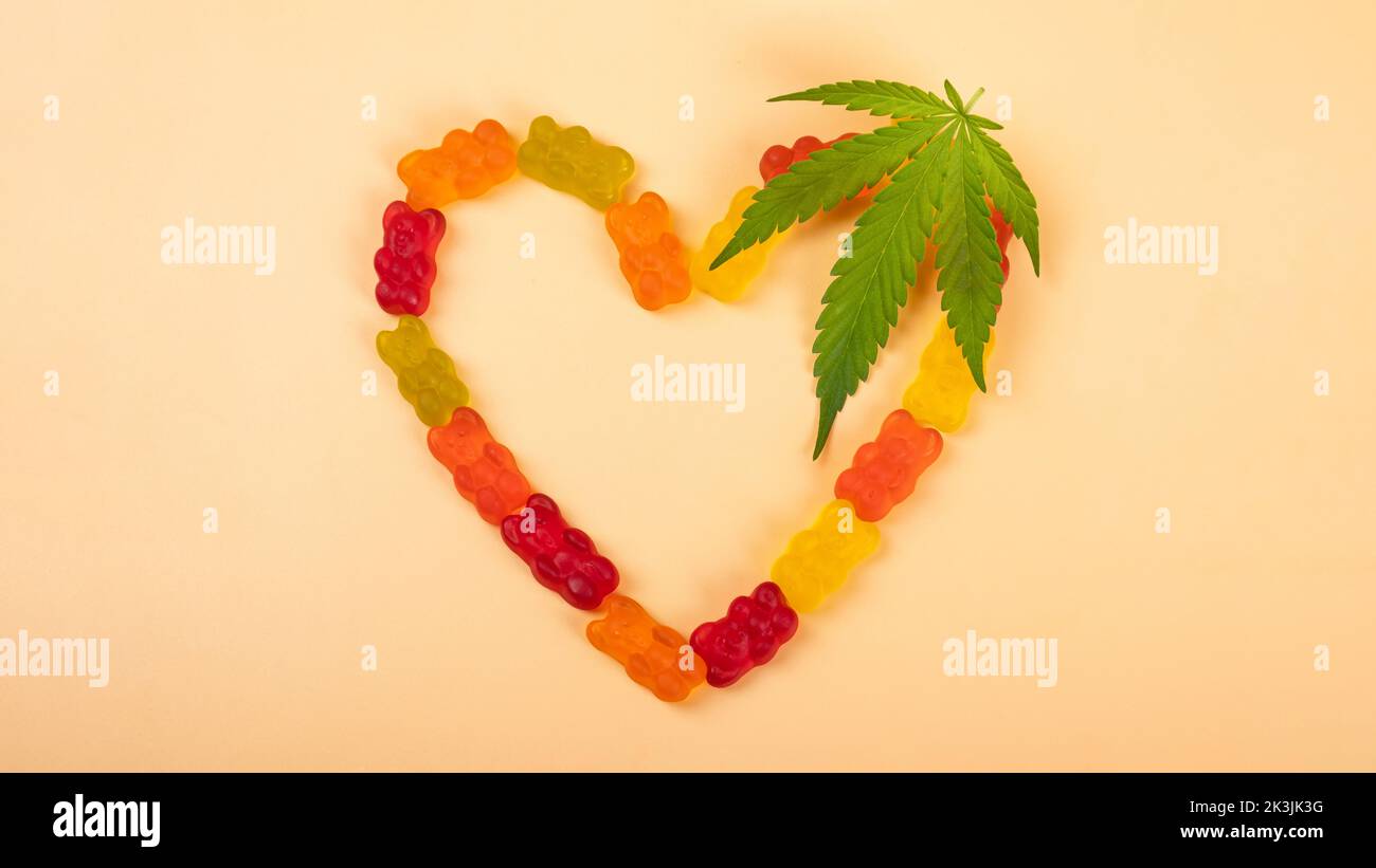 gelatina di cannabis cuore di candie e foglia verde, droghe ricreative. Foto Stock