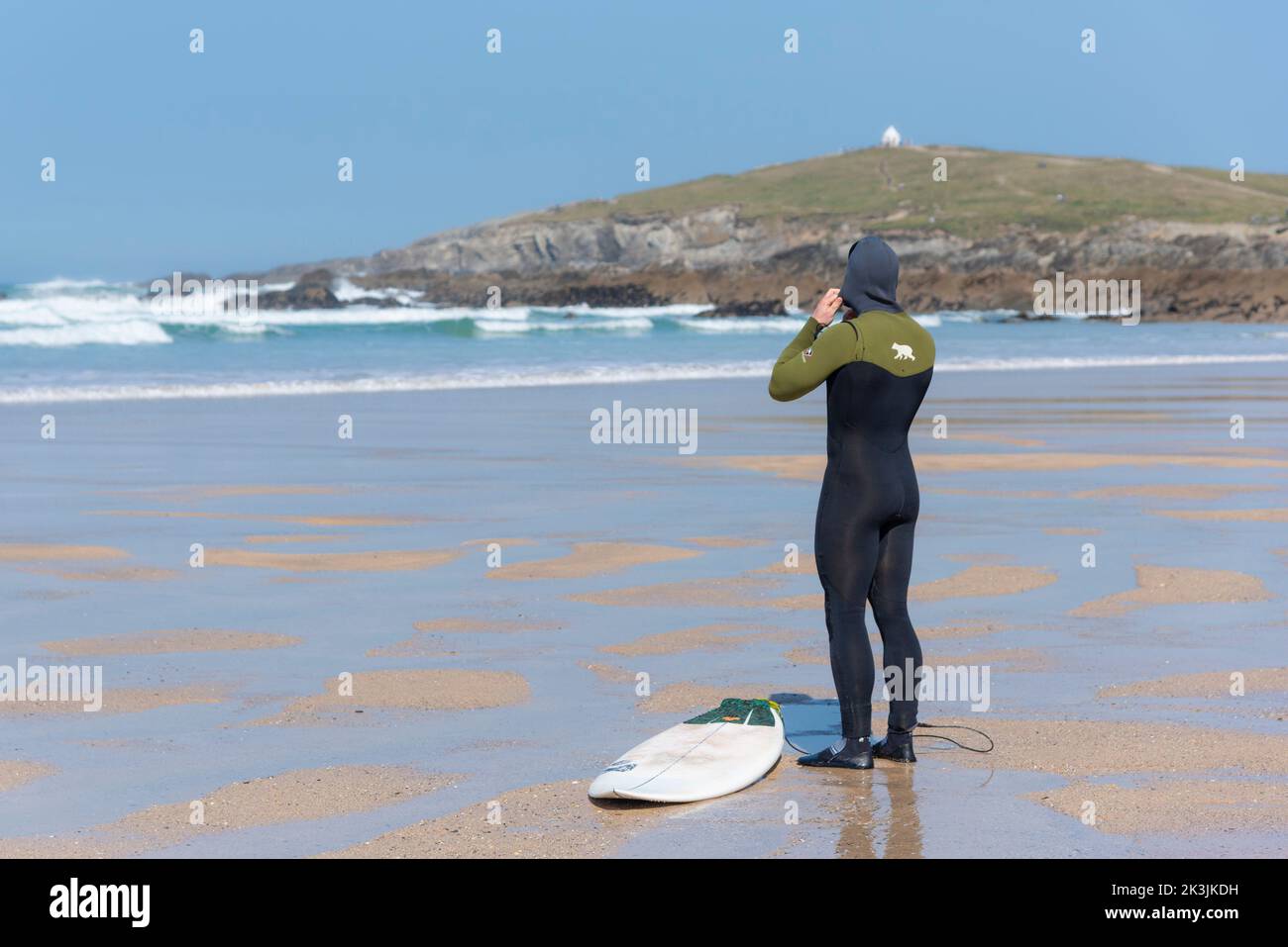 Un surfista che si prepara per una sessione di surf al Fistral di Newquay in Cornovaglia nel Regno Unito. Foto Stock