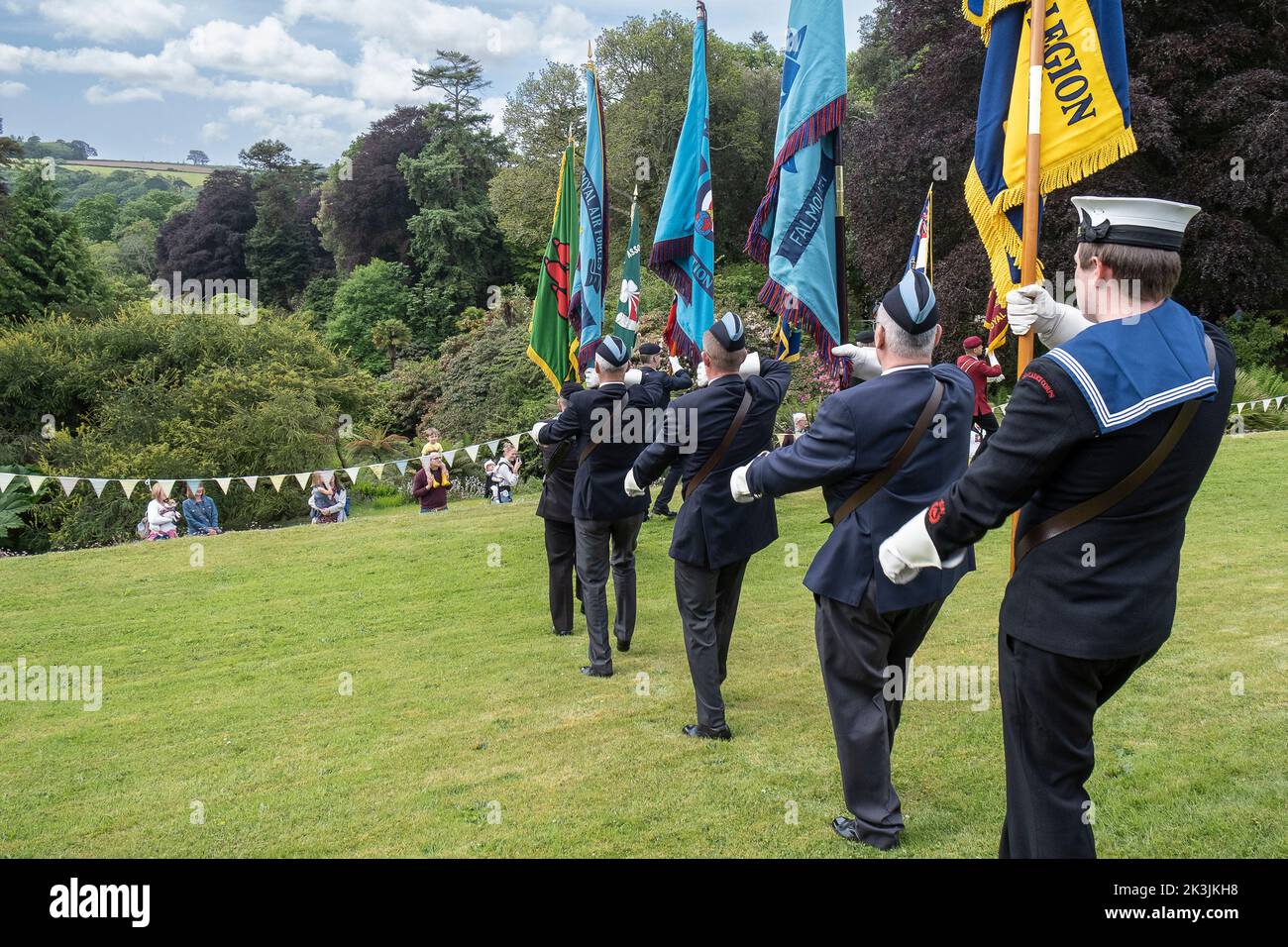 Vari standard dell'Associazione regimentali che vengono parati sul prato all'evento annuale della Giornata militare presso i Giardini di Trebah in Cornovaglia nel Regno Unito. Foto Stock