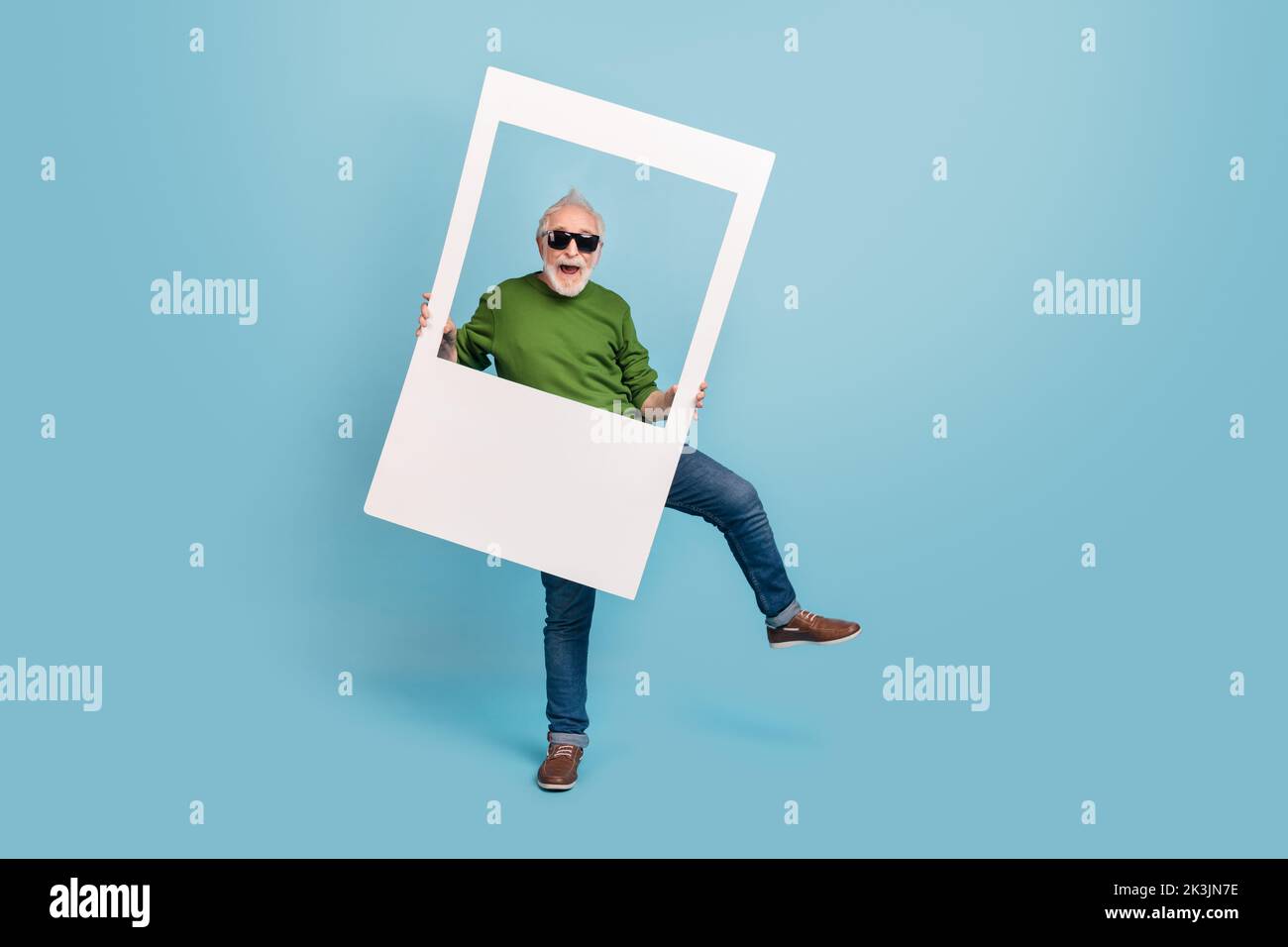 Foto a grandezza naturale di una persona spensierata e entusiasta tenere carta album scheda ballare isolato su sfondo di colore blu Foto Stock