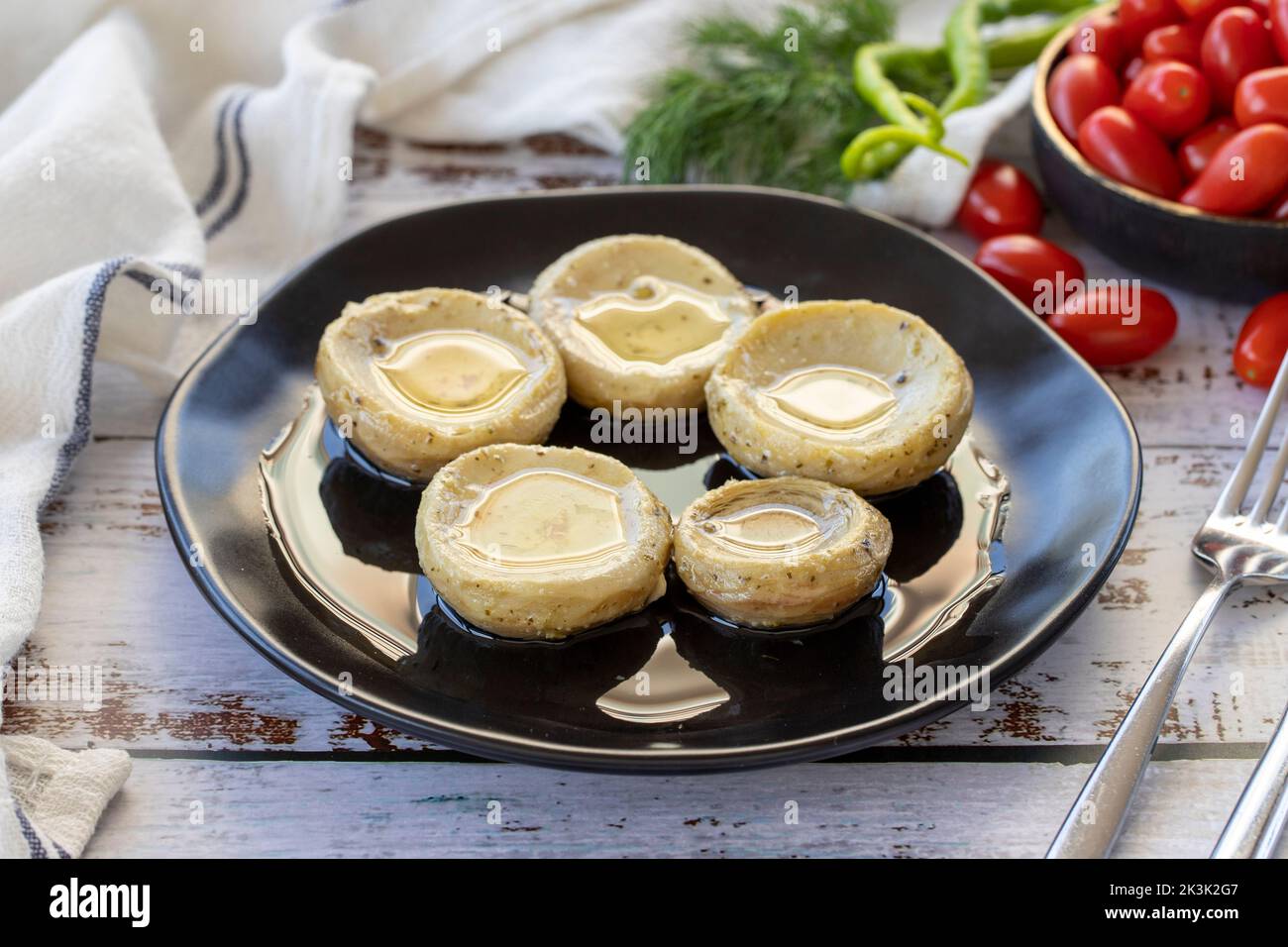 Carciofi con olio d'oliva. Carciofi su sfondo di legno. Cucina mediterranea. Primo piano Foto Stock