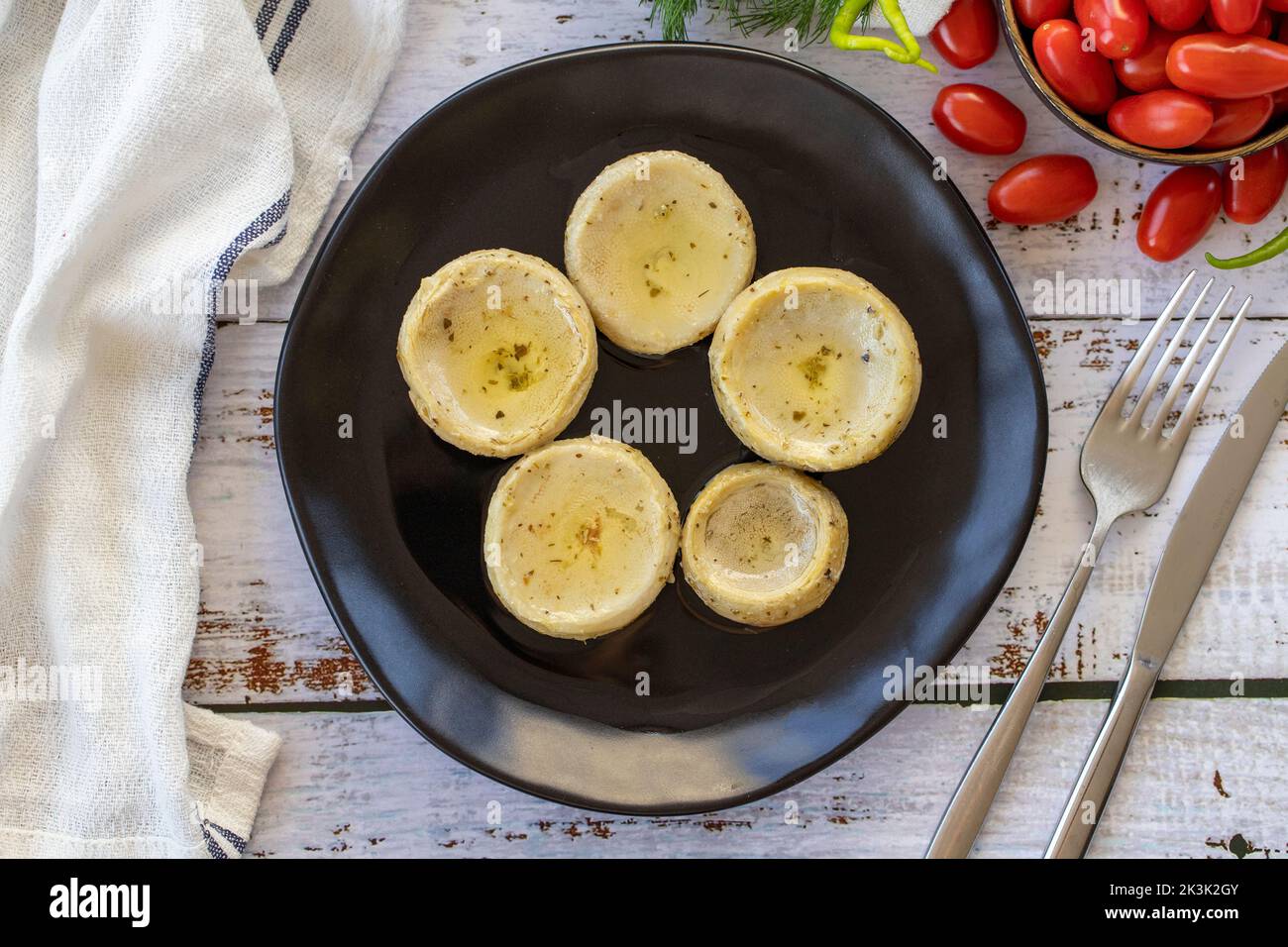 Carciofi con olio d'oliva. Carciofi su sfondo di legno. Cucina mediterranea. Vista dall'alto Foto Stock