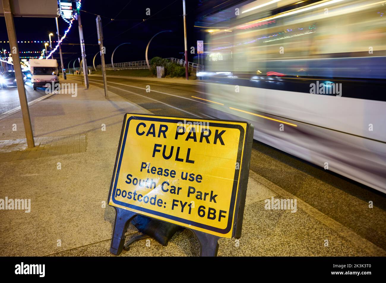 Tram che passa accanto al parcheggio, cartello con su scritto tutto sul lungomare di Blackpool Foto Stock