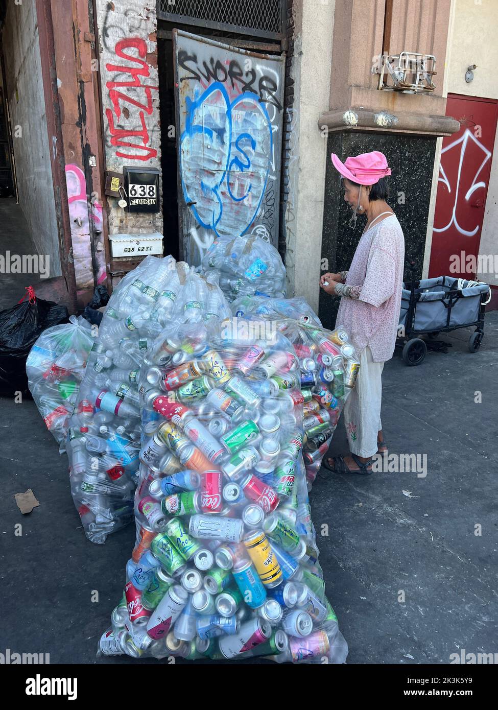 Una donna cinese attende di incassare in bottiglie di plastica e lattine di alluminio in occasione di uno scambio nel quartiere di Sunset Park a Brooklyn, New York. Foto Stock