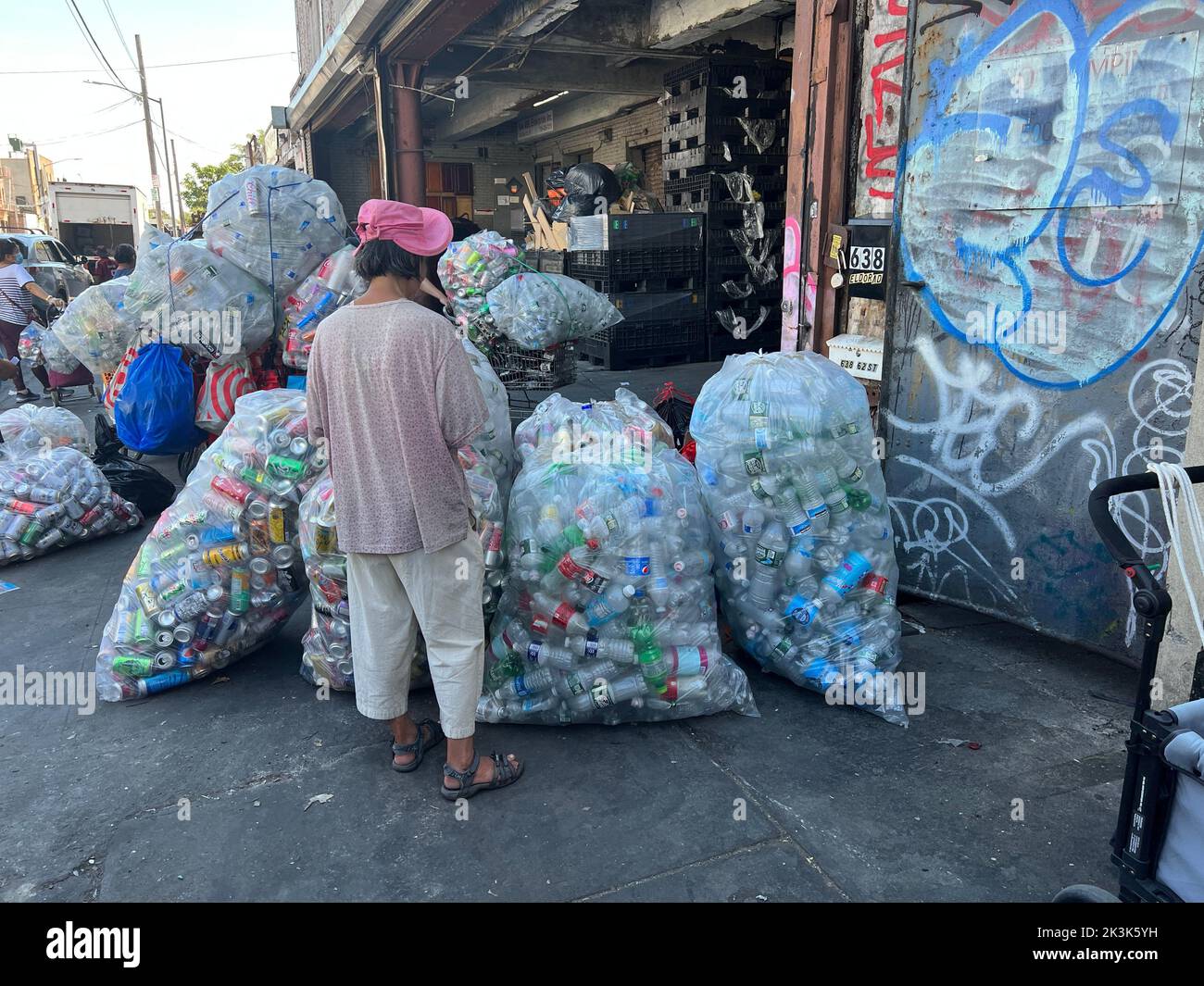 Una donna cinese attende di incassare in bottiglie di plastica e lattine di alluminio in occasione di uno scambio nel quartiere di Sunset Park a Brooklyn, New York. Foto Stock