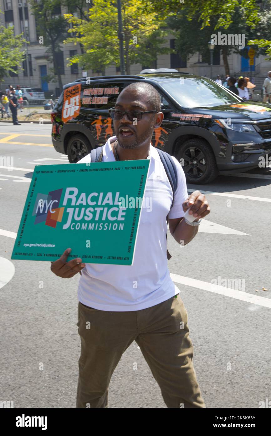 Il carnevale della Parata del giorno dell'India occidentale è una celebrazione annuale della cultura indiana occidentale, che si tiene ogni anno intorno al primo lunedì di settembre a Crown Heights, l'uomo porta un cartello che sostiene la giustizia razziale alla parata. Brooklyn, New York. Foto Stock