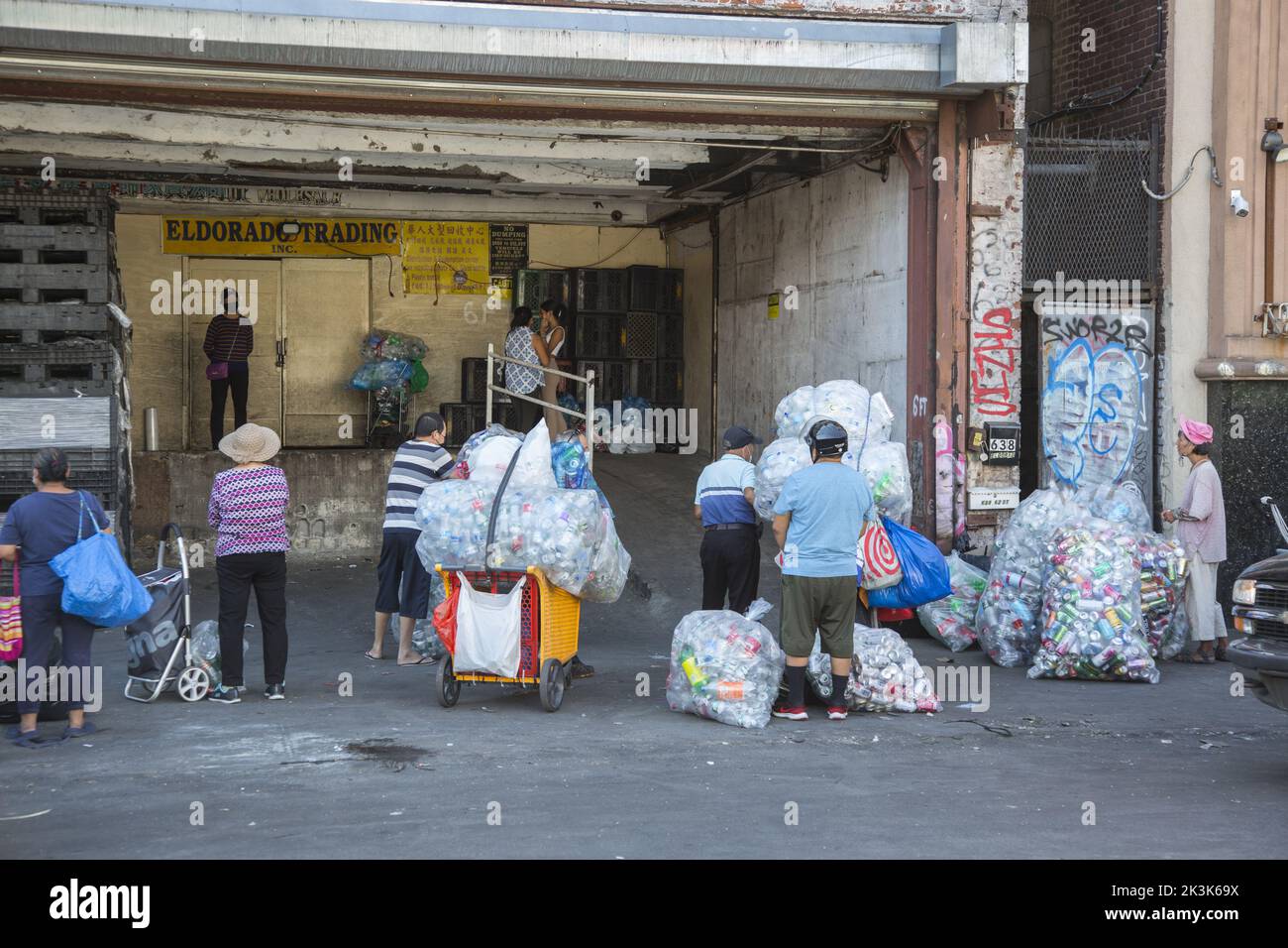 Le persone aspettano di incassare in bottiglie di plastica e lattine di alluminio in uno scambio nel quartiere di Sunset Park di Brooklyn, New York. Foto Stock