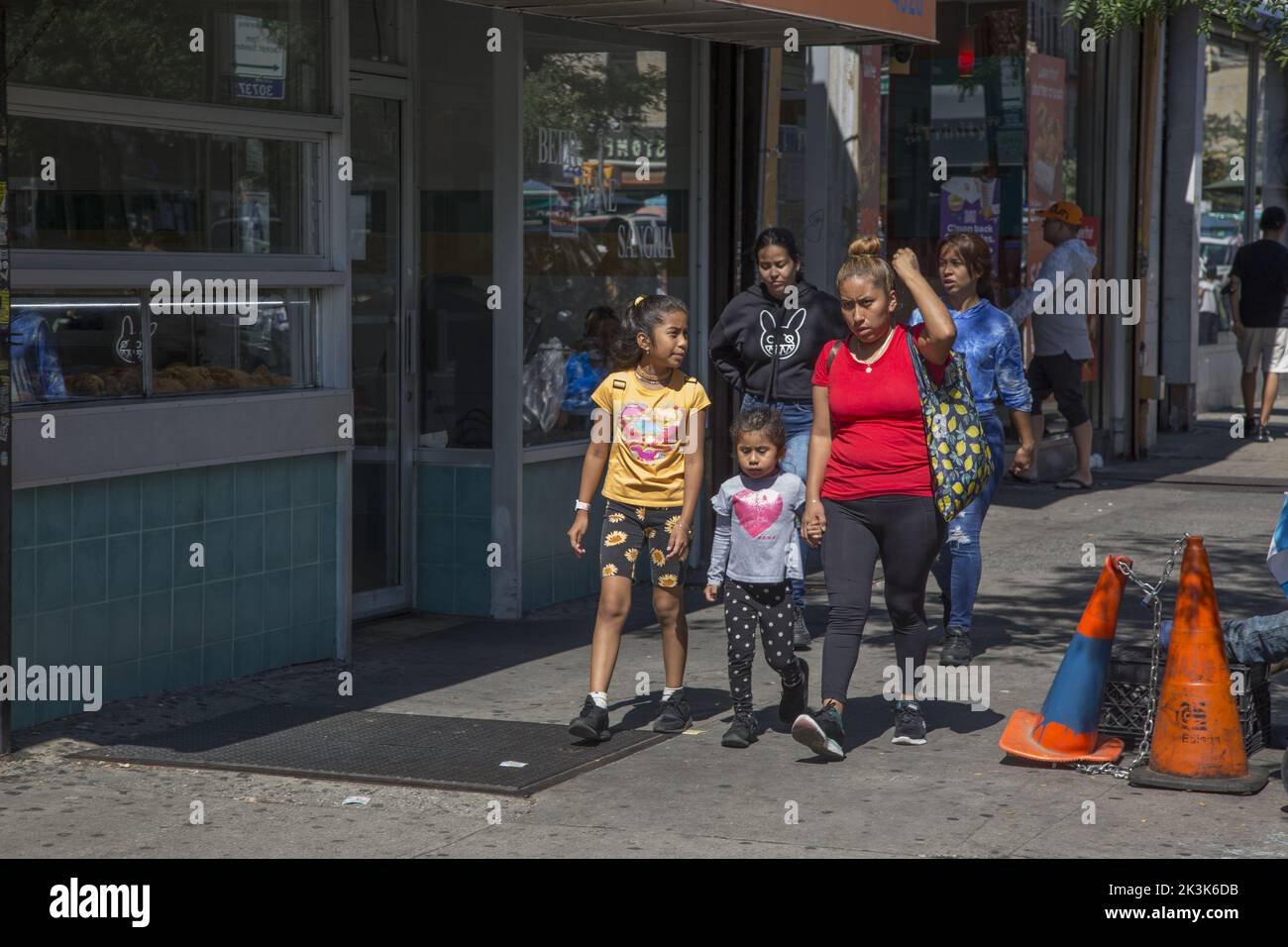 Mamma con bambini cammina lungo la 5th Avenue nel quartiere altamente ispanico e multietnico di Sunset Park a Brooklyn, New York. Foto Stock