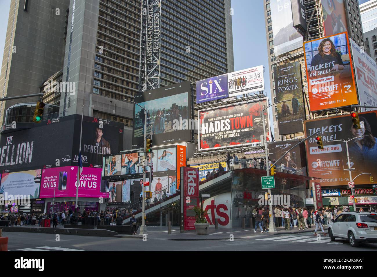 Le persone si allineano per acquistare biglietti scontati per il teatro a Times Square con cartelloni pubblicitari in sottofondo lungo Broadway a New York City. Foto Stock