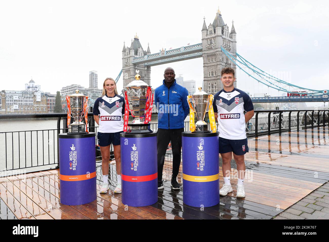 USO EDITORIALE SOLO ex giocatore di rugby inglese, Martin Offiah (centro) si unisce a Jodie Cunningham (sinistra) giocatore di Donne d'Inghilterra e Tom Halliwell (destra) giocatore di Wheelchair d'Inghilterra con i trofei vicino a Tower Bridge, Londra per celebrare la lotteria nazionale come partner ufficiale della prossima Rugby League World Cup 2021 (RLWC2021). Data immagine: Martedì 27 settembre 2022. Foto Stock