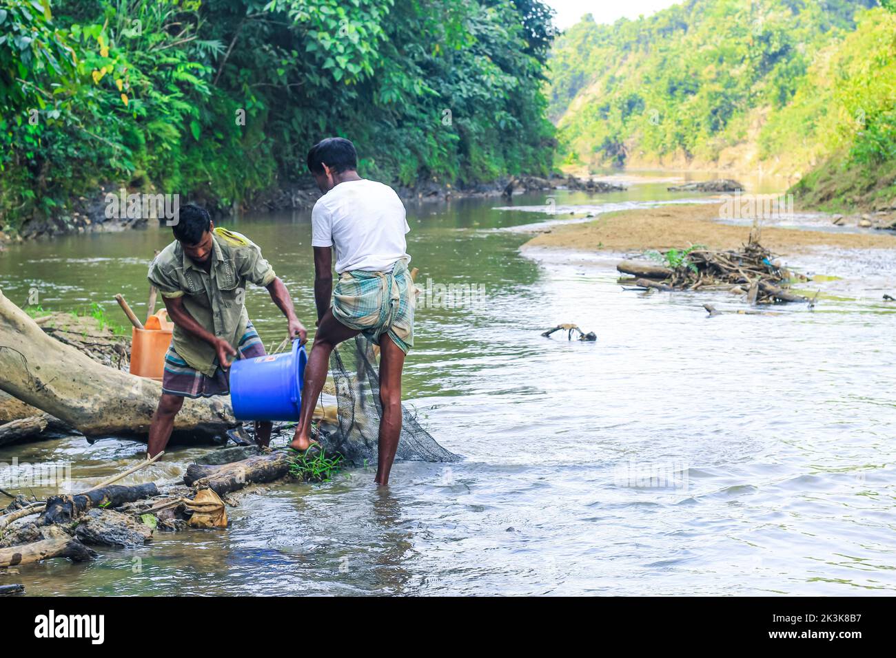 I pescatori tribali pescano con le reti da pesca nel torrente. I tribali hanno il loro proprio metodo di pesca. Foto Stock