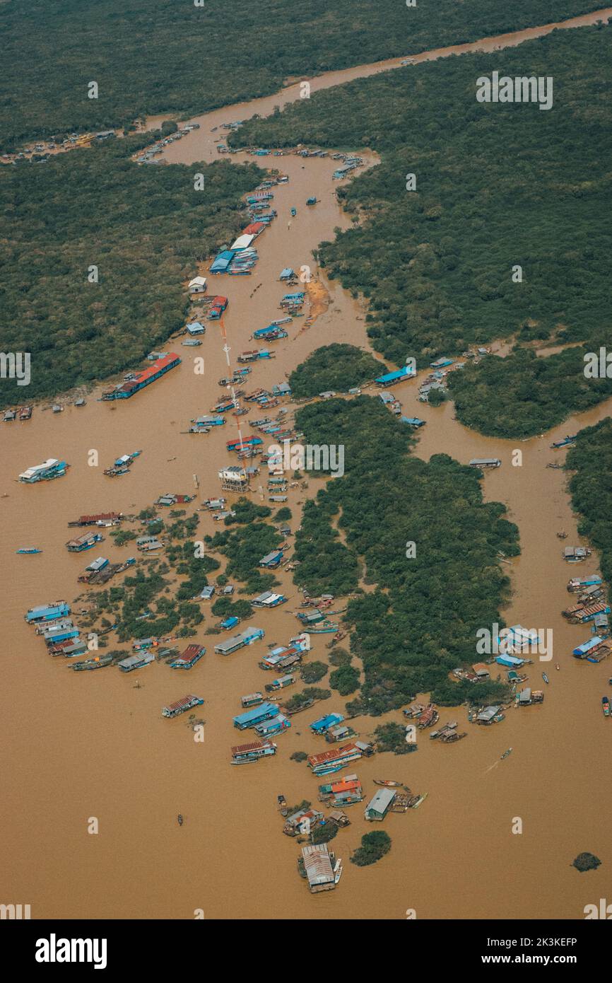 Una vista aerea del fiume cambogiano circondato da barche e alberi Foto Stock