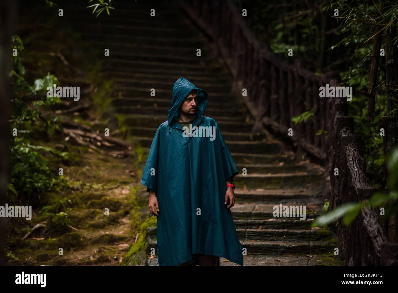 Uomo che indossa un impermeabile camminando nella natura Foto Stock